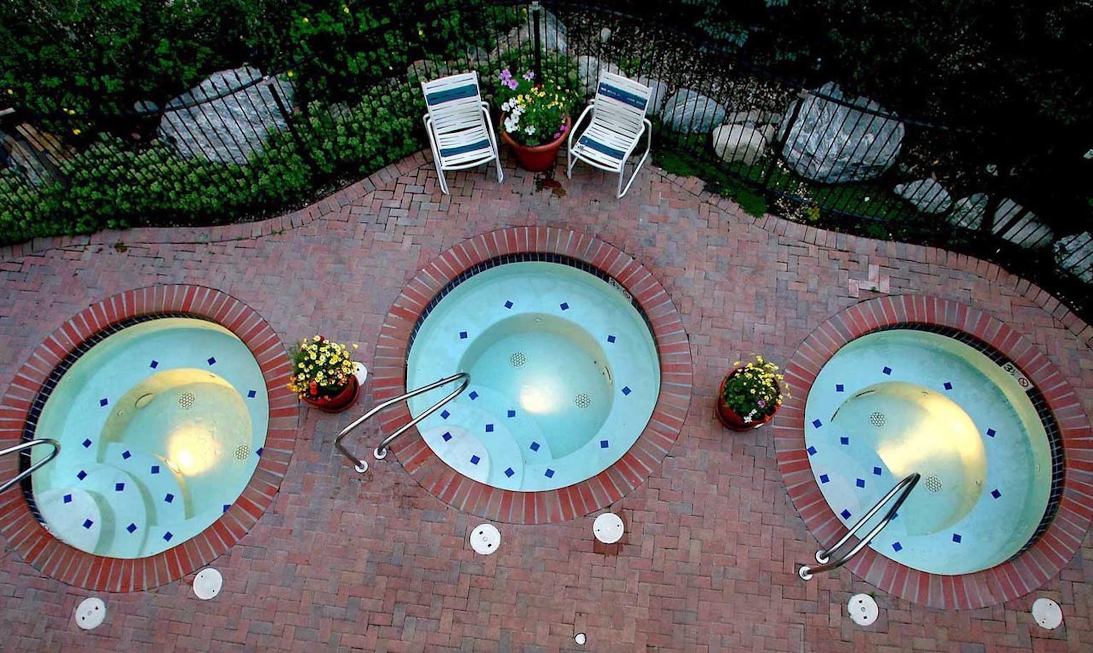 Relax in one of three charming hot tubs on a private brick patio