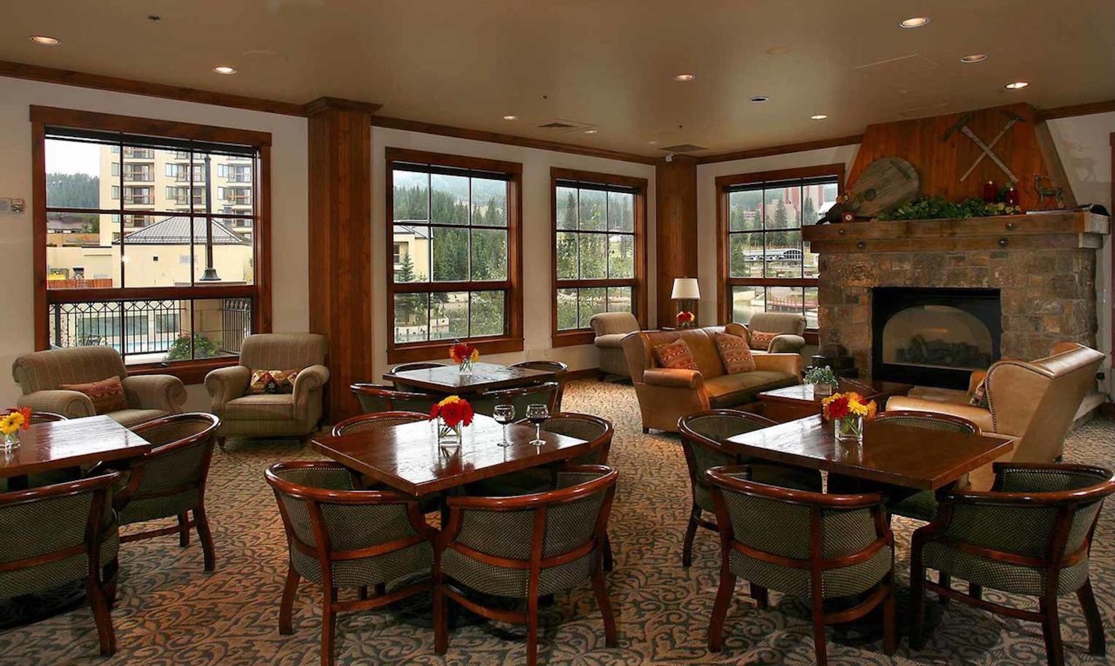 Warm lodge-style lounge with fireplace, ample seating, and scenic windows