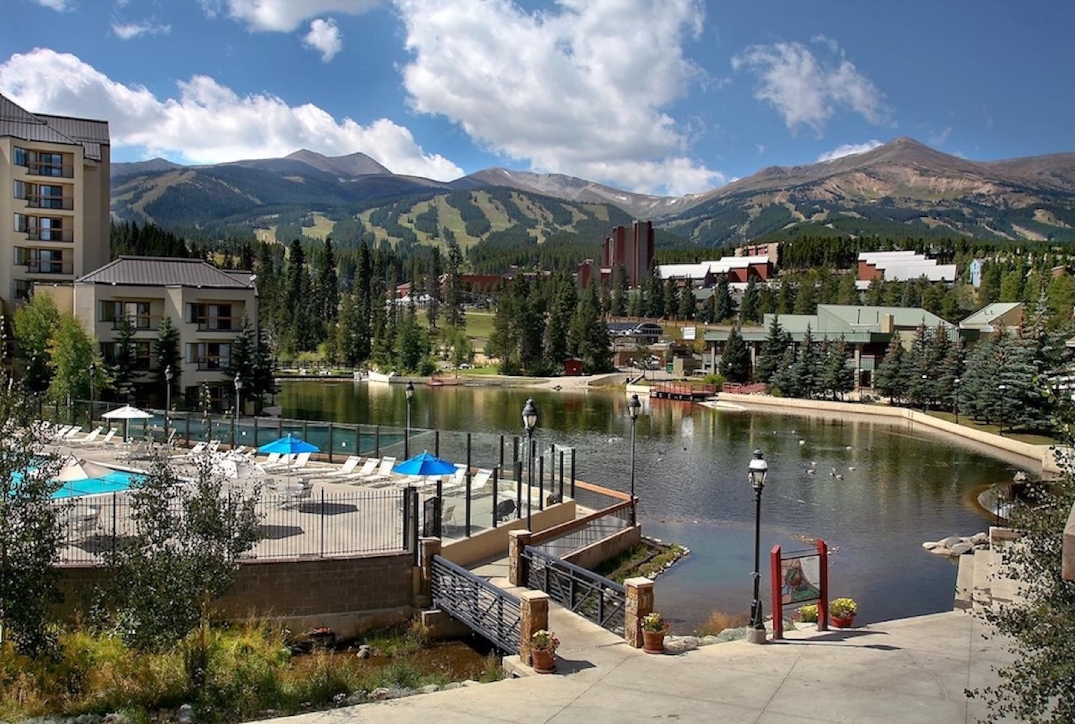 Scenic mountain resort with lake views, pool deck, and stunning alpine backdrop