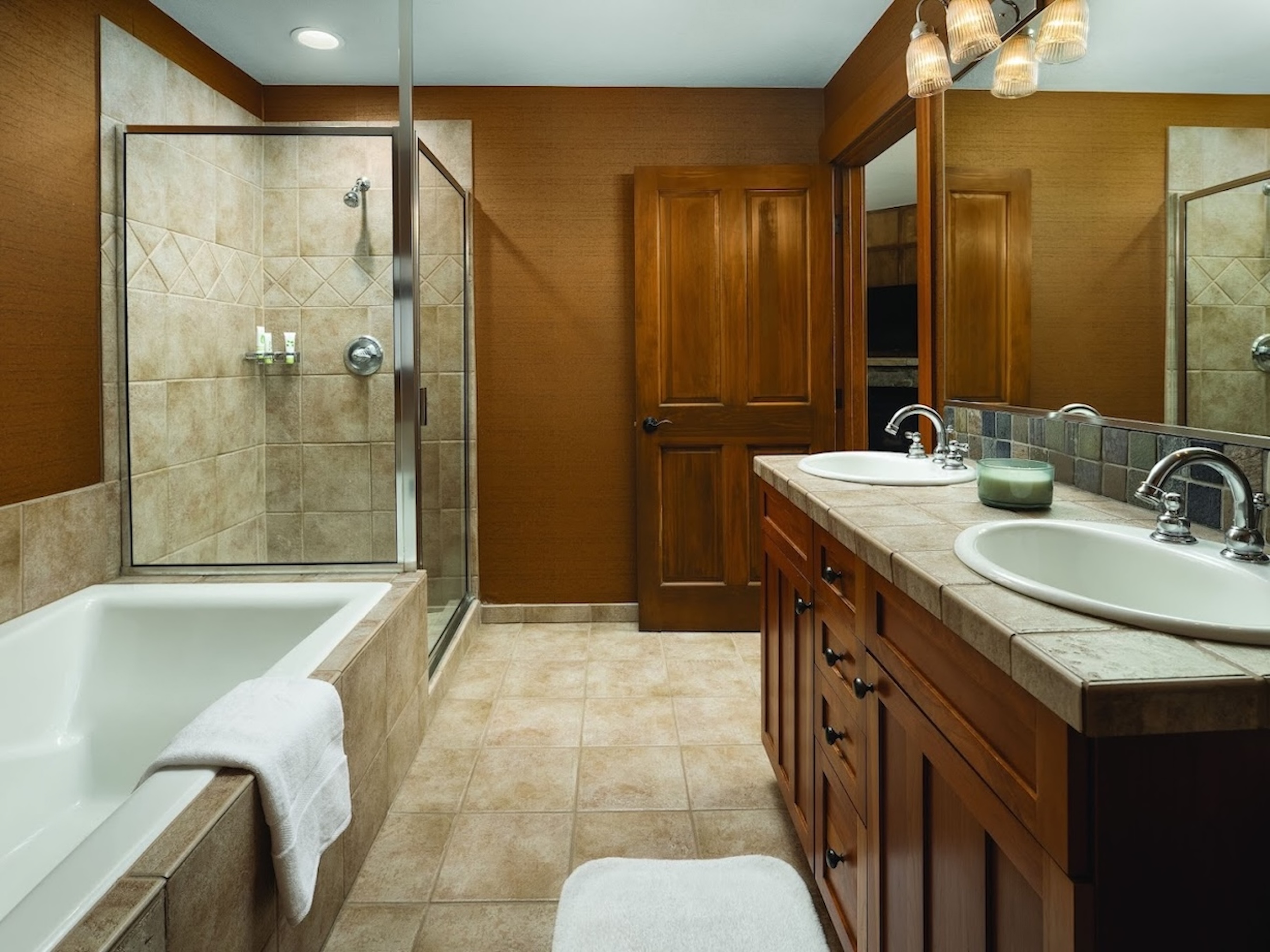Spa-like bathroom with dual vanity, soaking tub, and separate glass shower