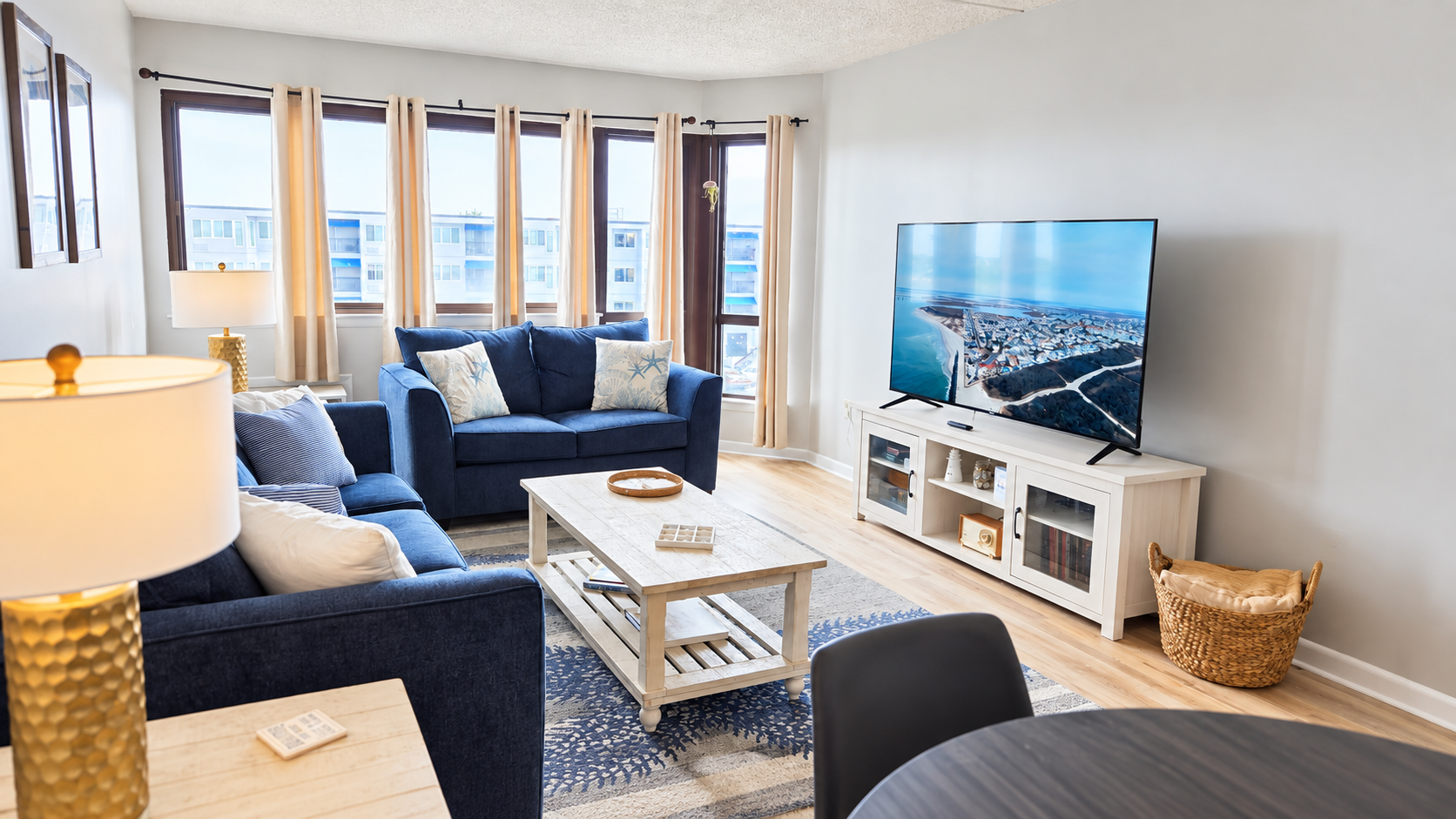 Bright coastal-style living room with large windows and big-screen TV