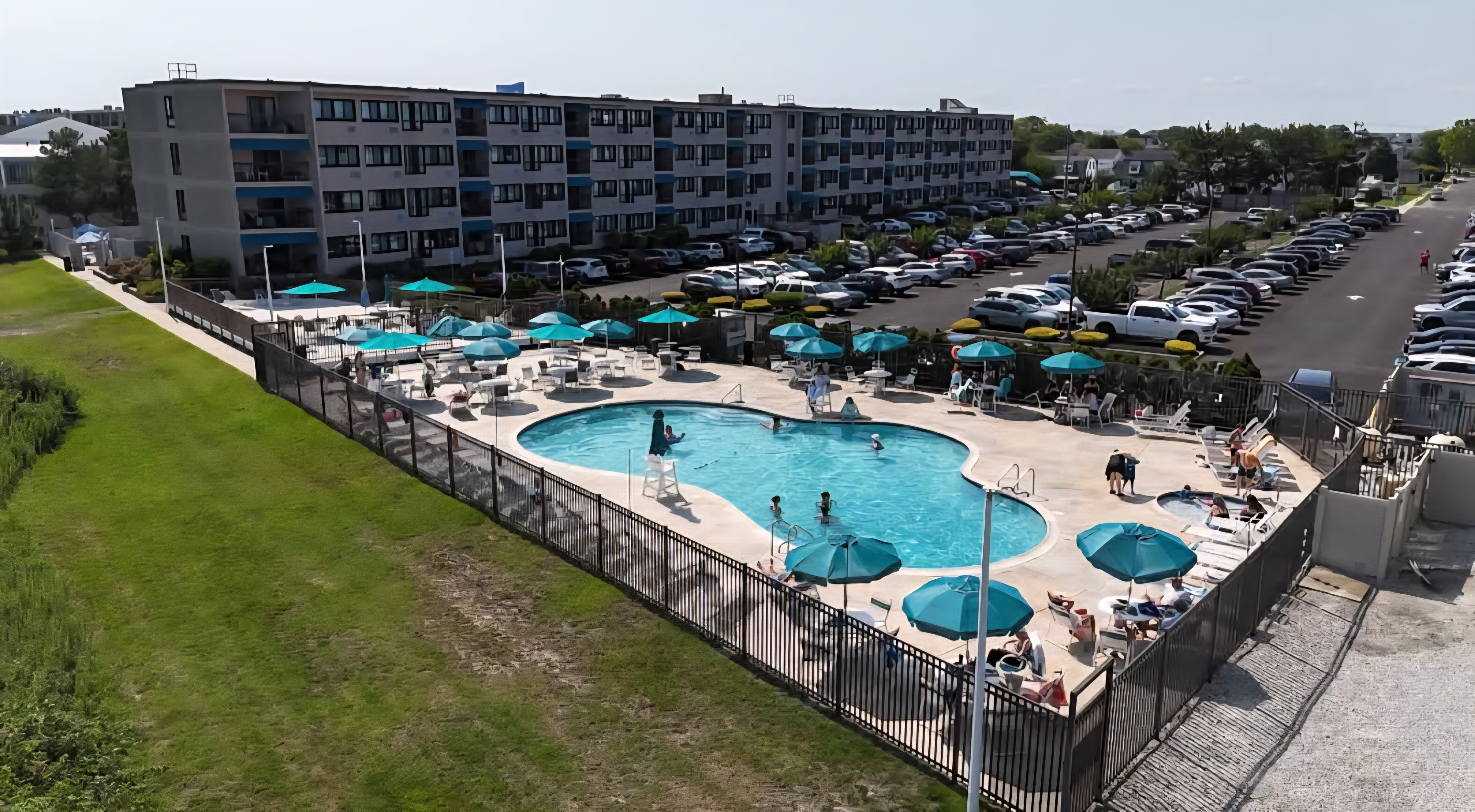 Spacious resort-style pool deck with lounge seating and shaded umbrellas