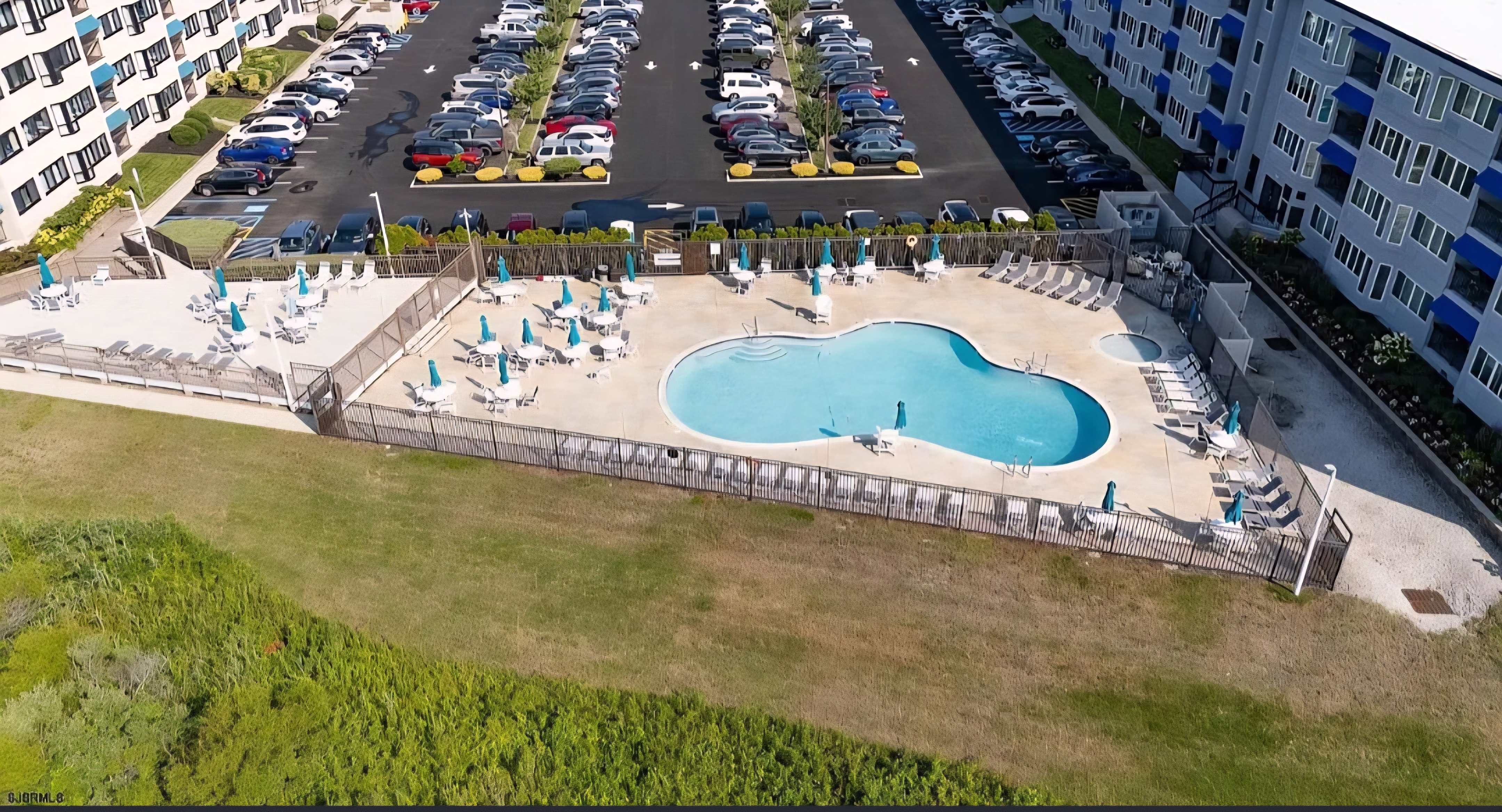 Resort-style pool deck with loungers, umbrellas, and easy on-site parking