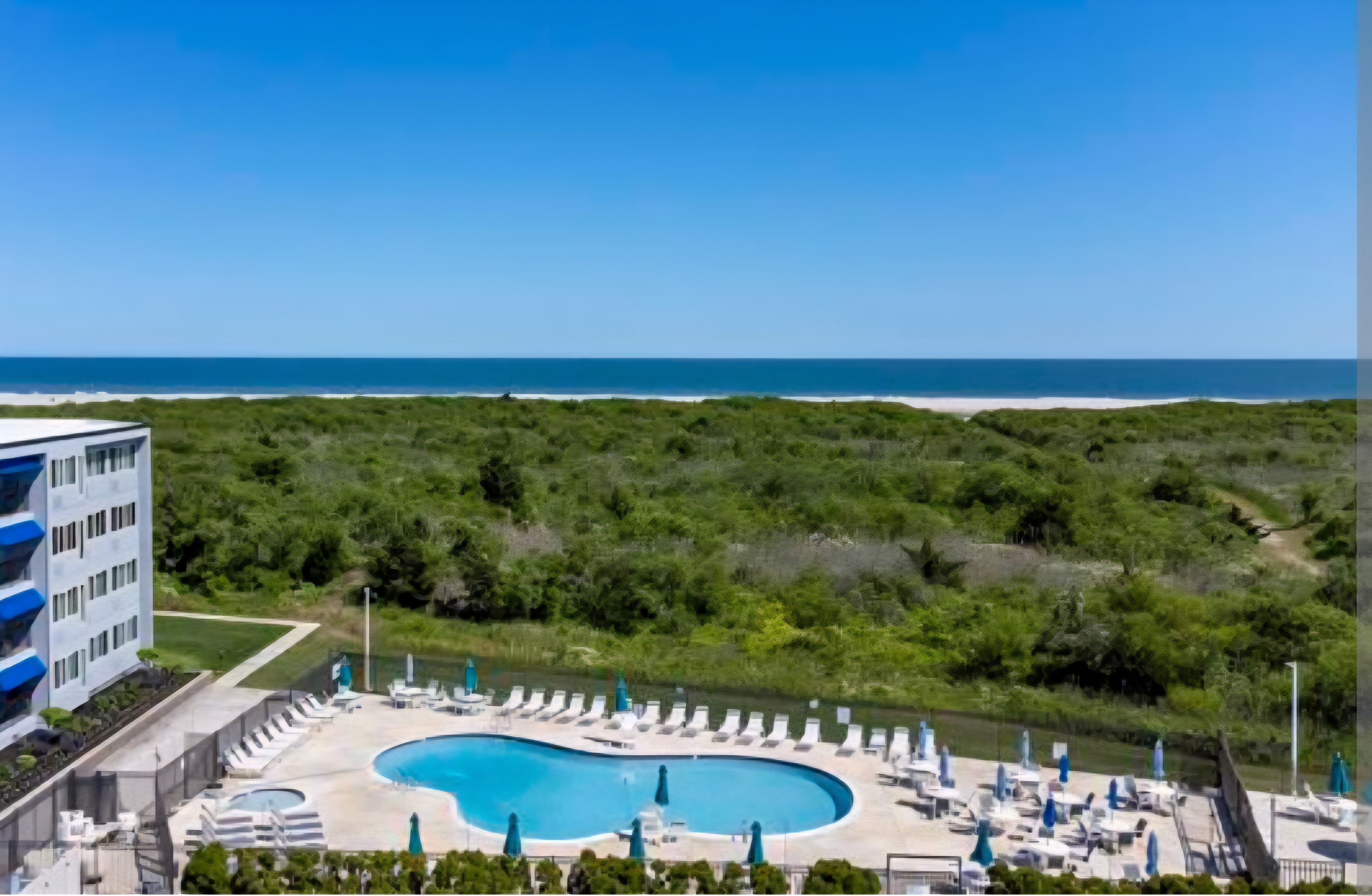Resort-style pool deck with ocean views and easy beach access