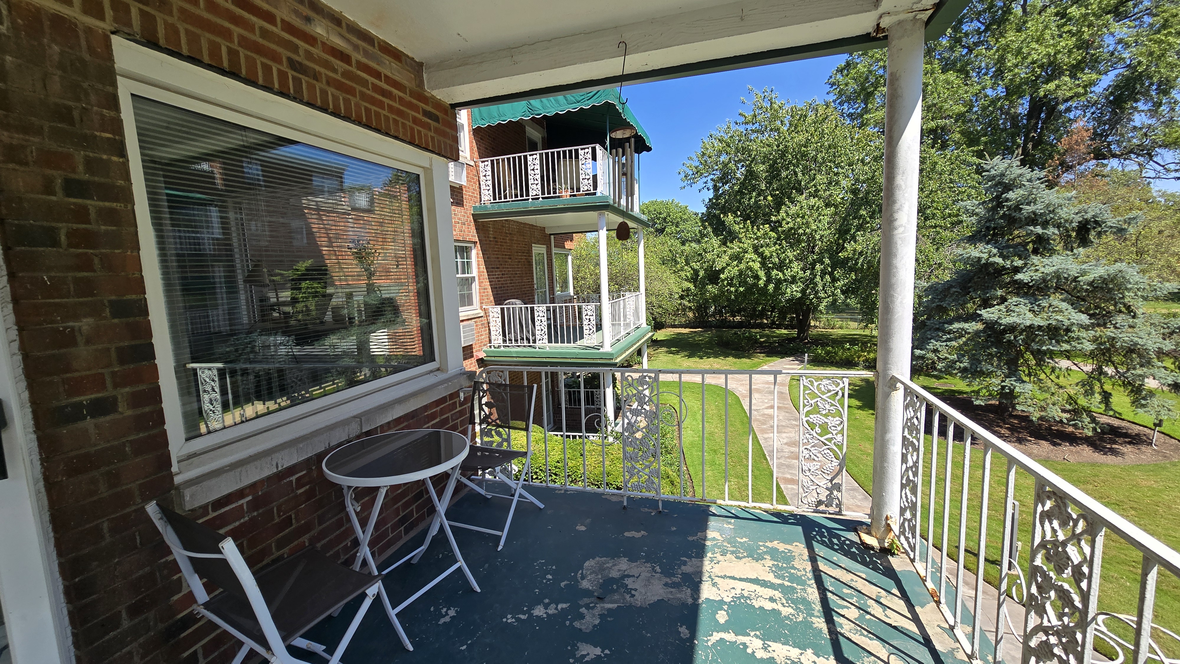 Private balcony with bistro seating and leafy green views