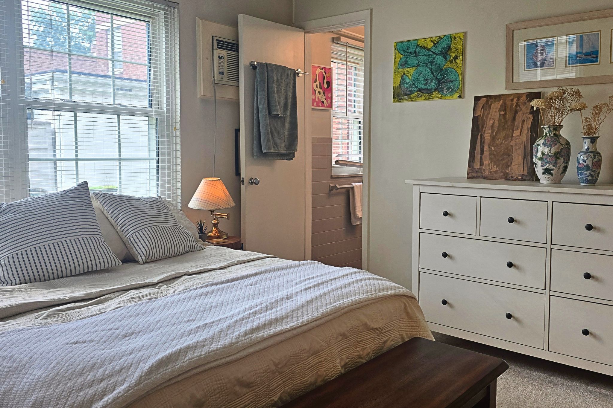 Bright, cozy bedroom with natural light and en suite bathroom access