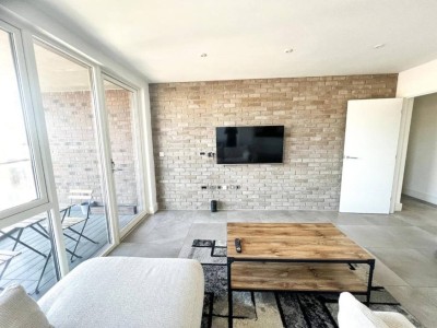 Living area with feature brick wall and wall-mounted TV