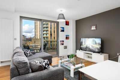 Living room with smart TV, shelving and dining space