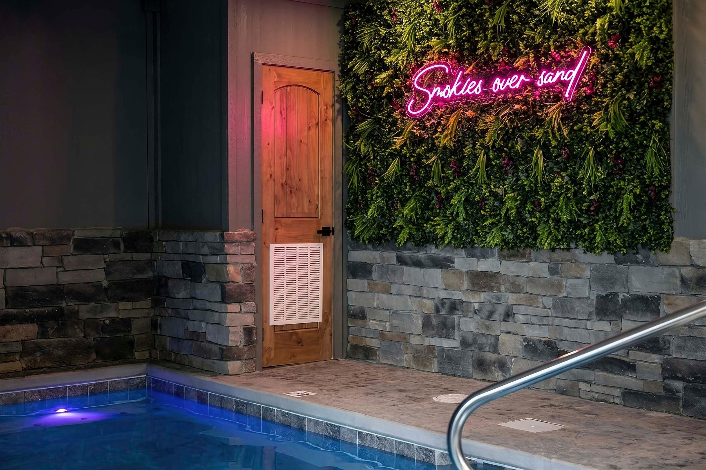 Indoor pool with neon feature wall and upscale resort-style ambiance