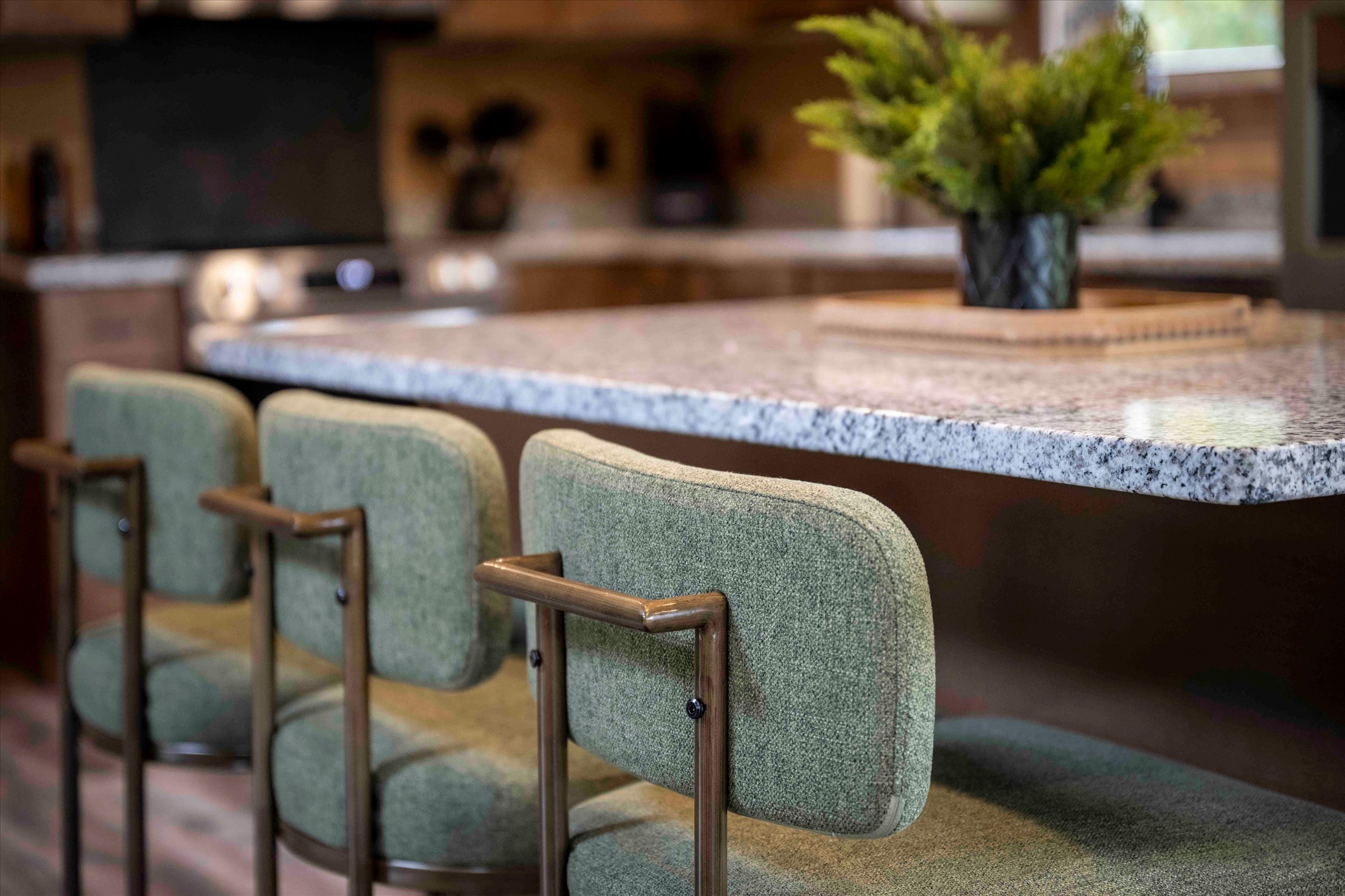 Inviting kitchen island with plush seating and polished stone countertops