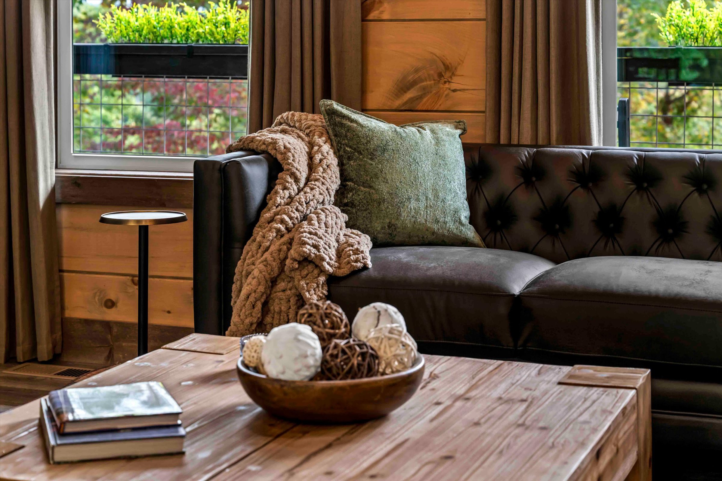 Cozy woodsy lounge with leather sofa, warm textures, and cabin charm