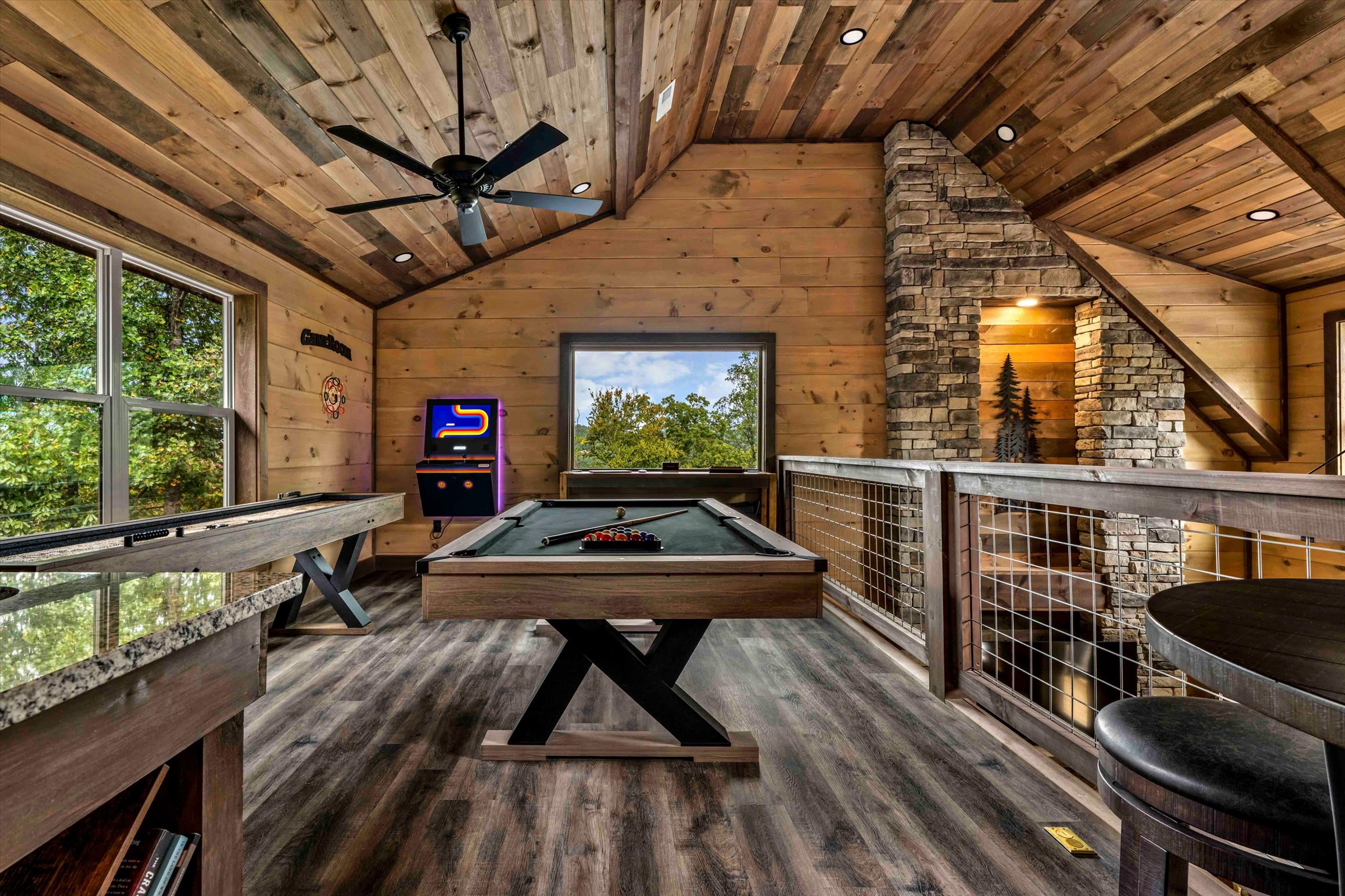 Rustic loft game room with pool, shuffleboard, arcade, and scenic views