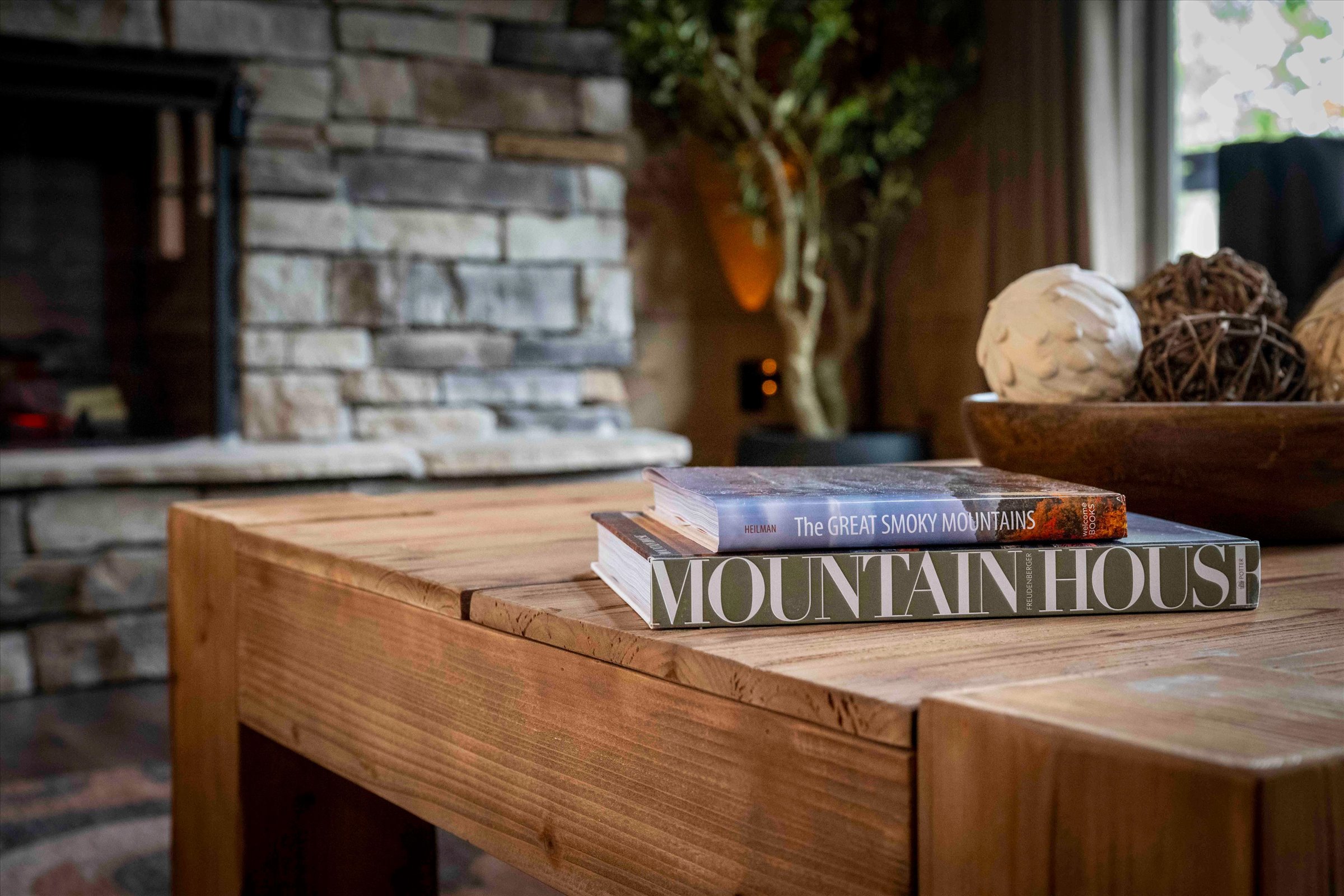 Rustic coffee table and stone fireplace create a cozy cabin retreat