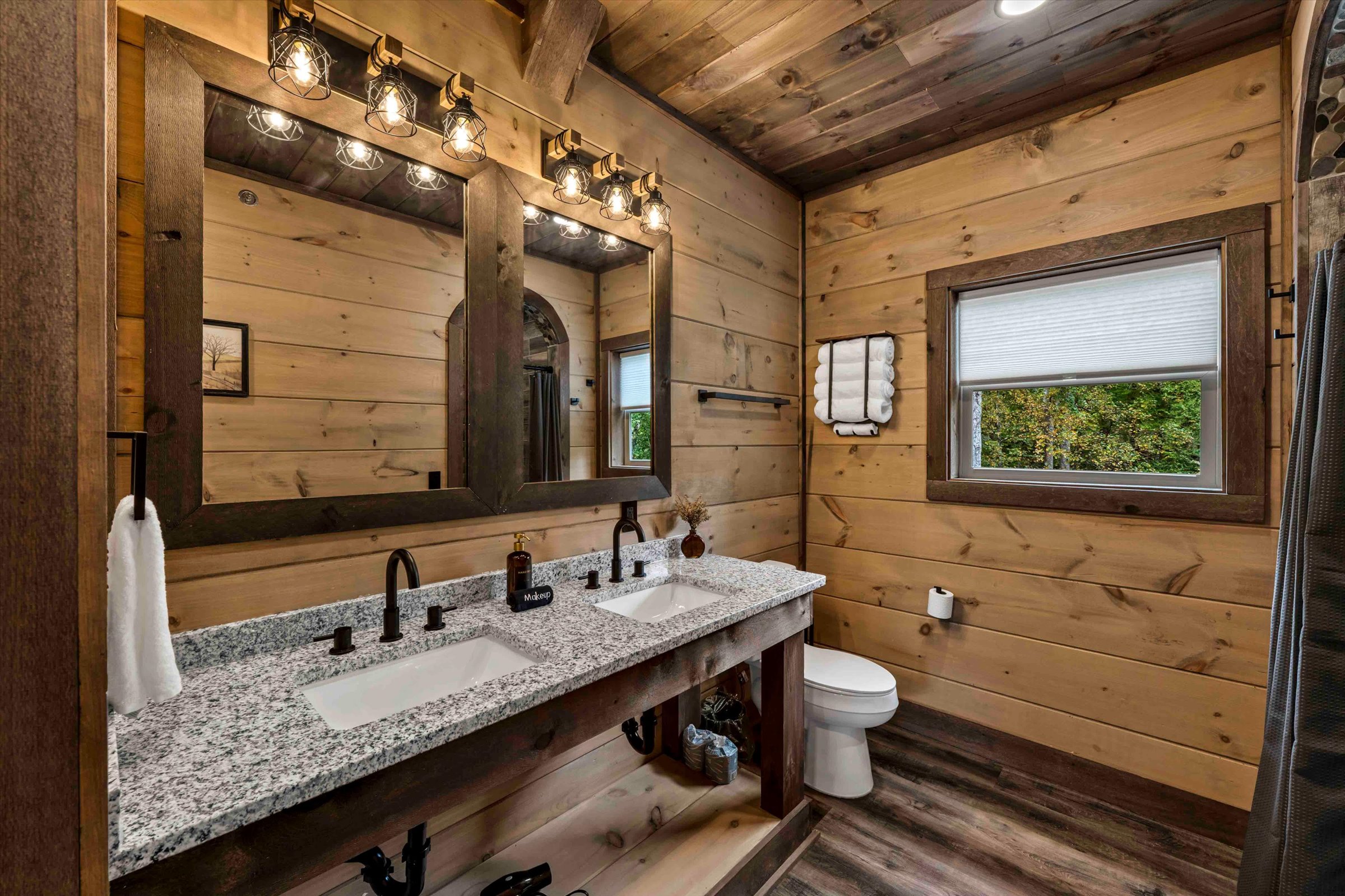 Rustic spa-style bathroom with double vanity and warm wood finishes