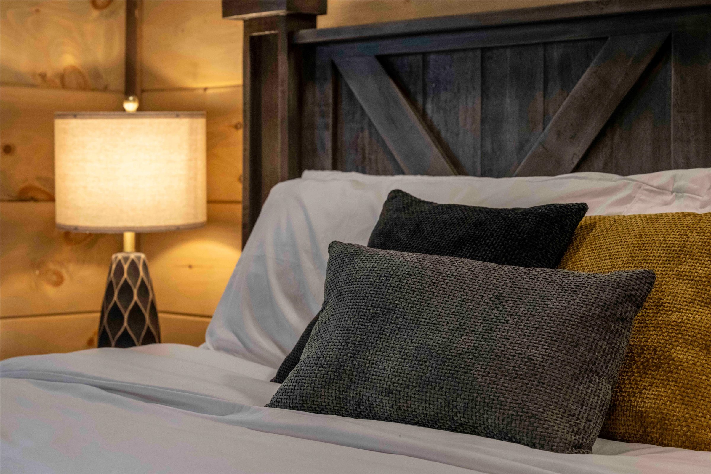 Cozy rustic bedroom with warm lighting and inviting plush bedding