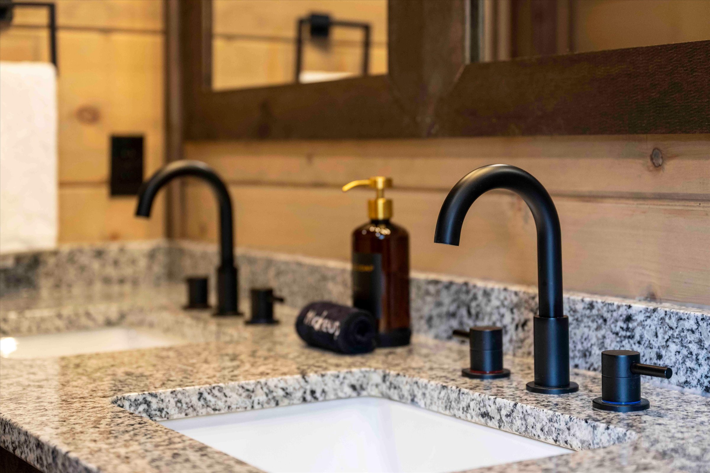 Elegant double vanity with granite counters and modern matte black fixtures