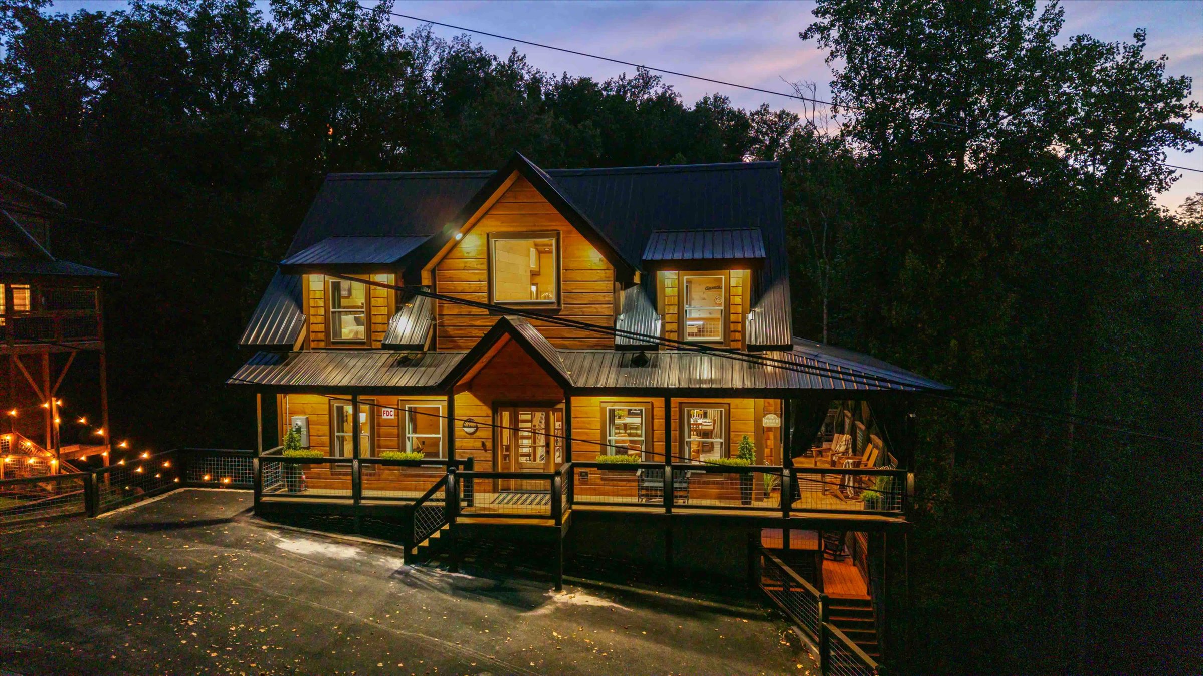 Cozy forest cabin with wraparound porch and glowing evening charm