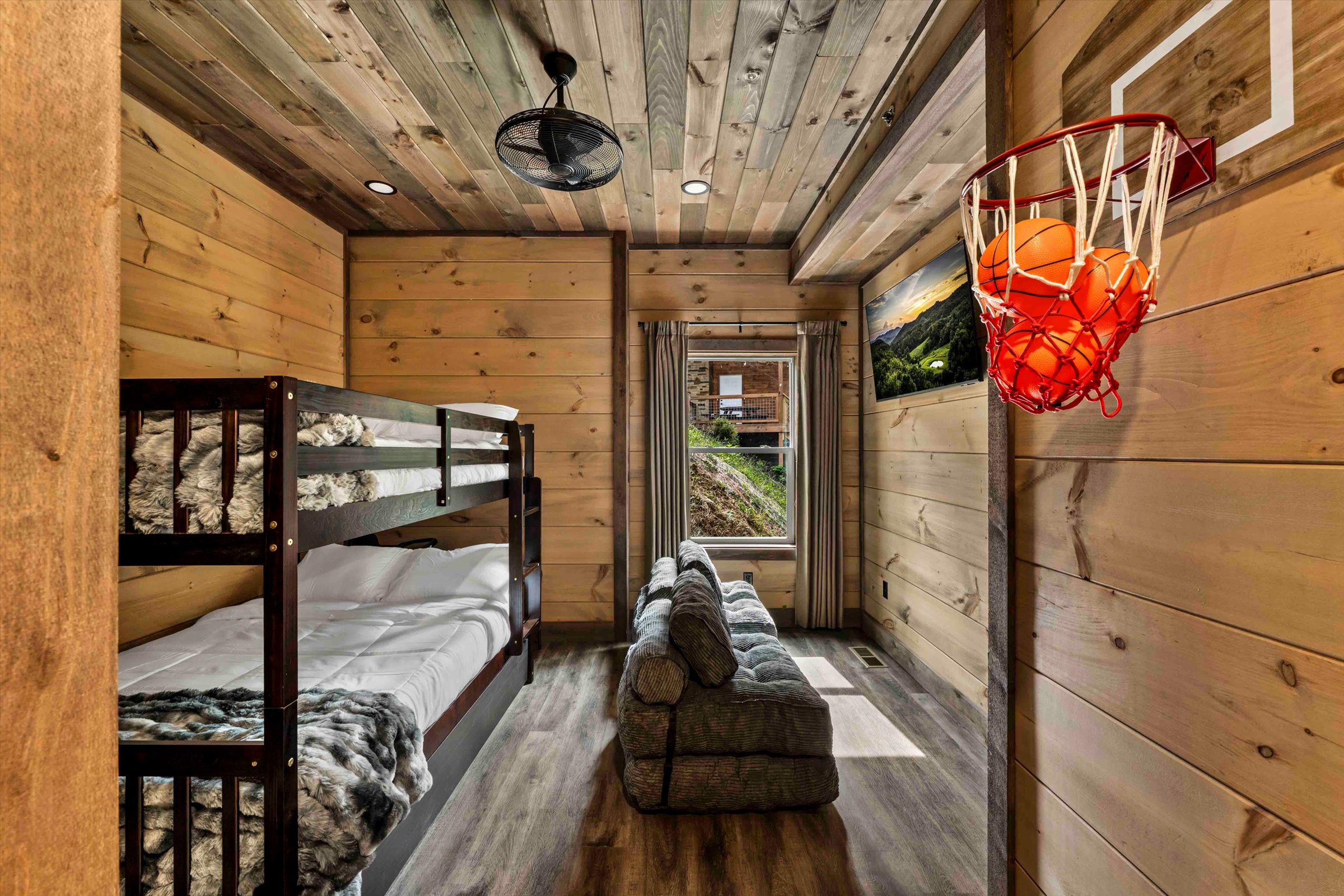 Rustic bunk room with lounge sofa and fun indoor basketball hoop
