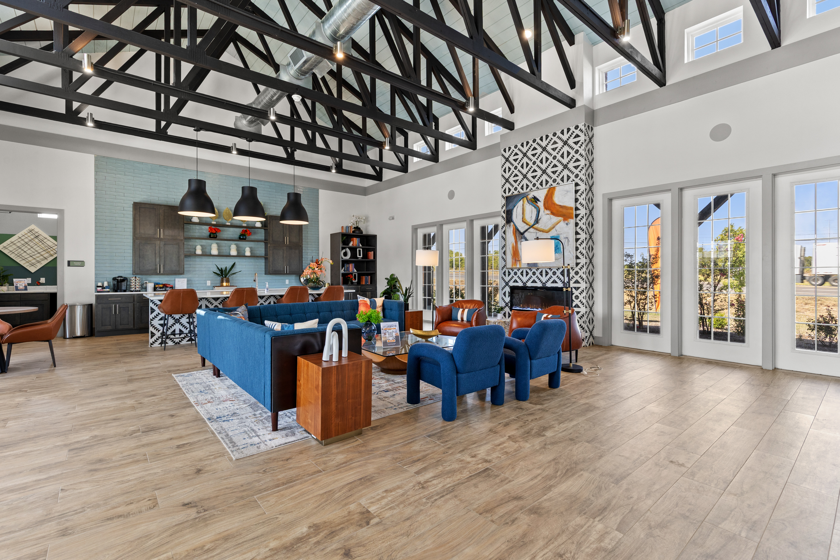 Bright designer lounge with soaring ceilings, stylish seating, and a full kitchen