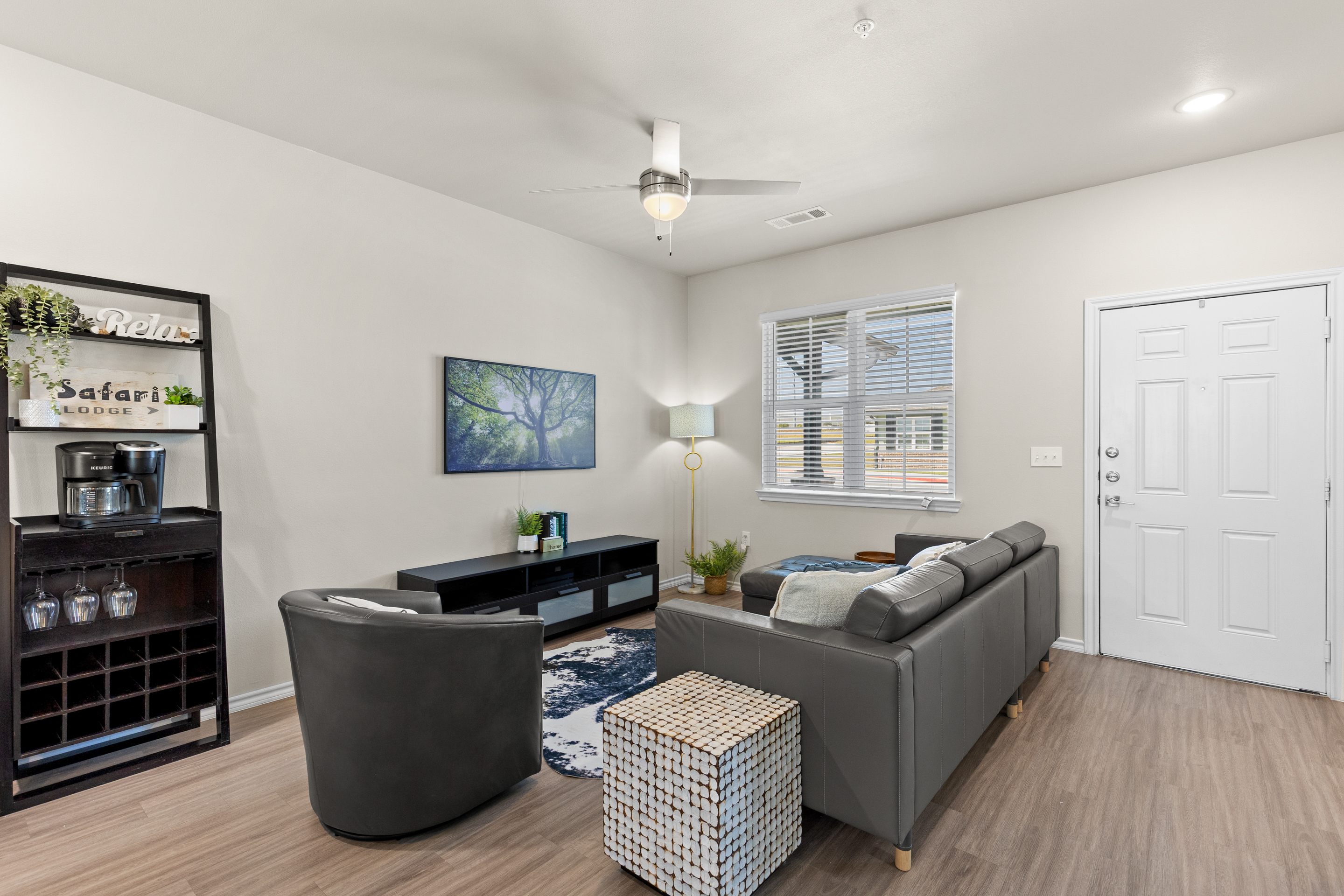 Bright modern living room with cozy seating and a stylish coffee bar