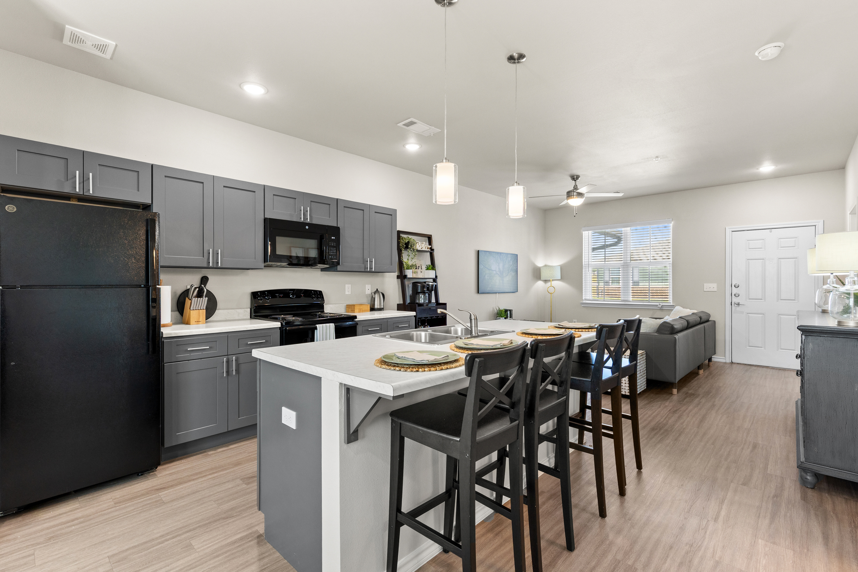 Modern open-concept kitchen and living space with island seating for 4
