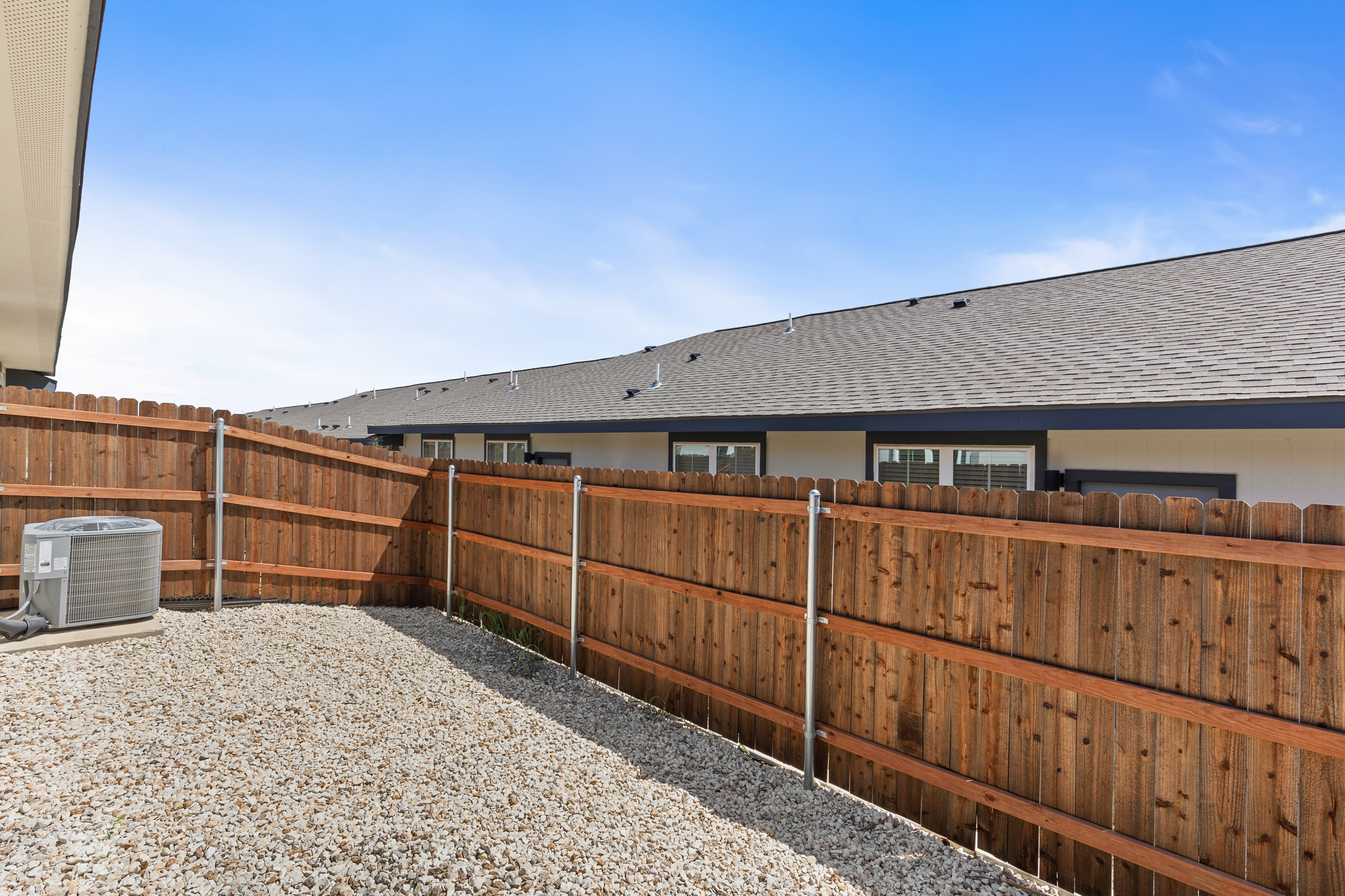 Private fenced yard with low-maintenance gravel landscaping