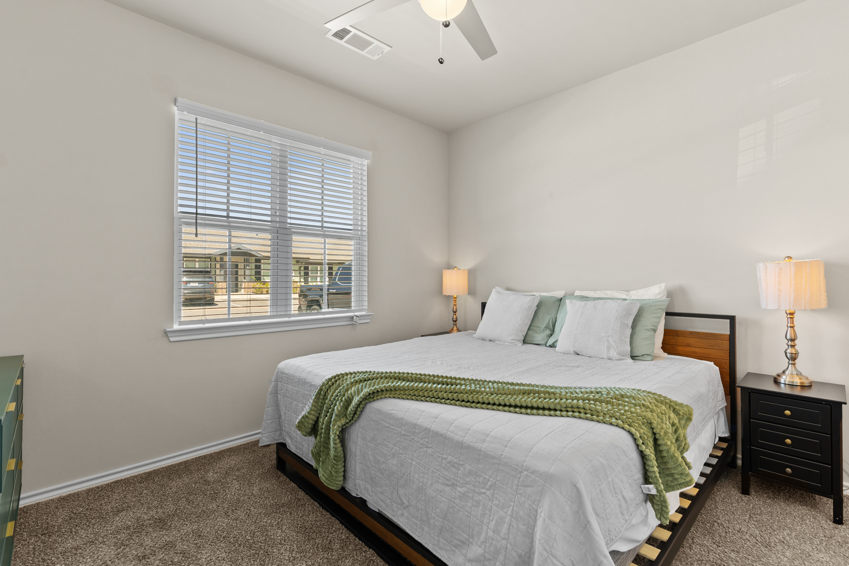 Bright, cozy bedroom with king bed, natural light, and stylish touches
