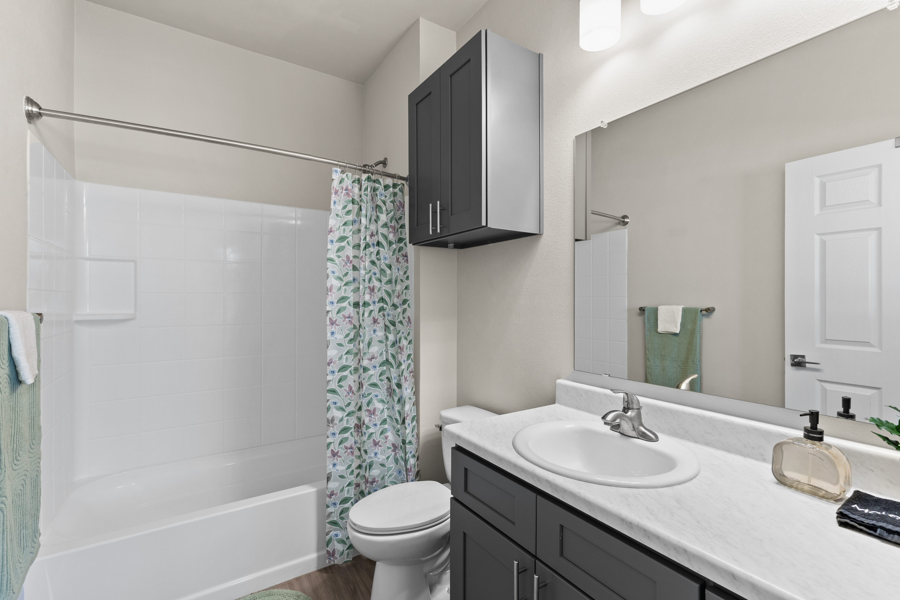 Bright modern bathroom with tub/shower combo and stylish vanity