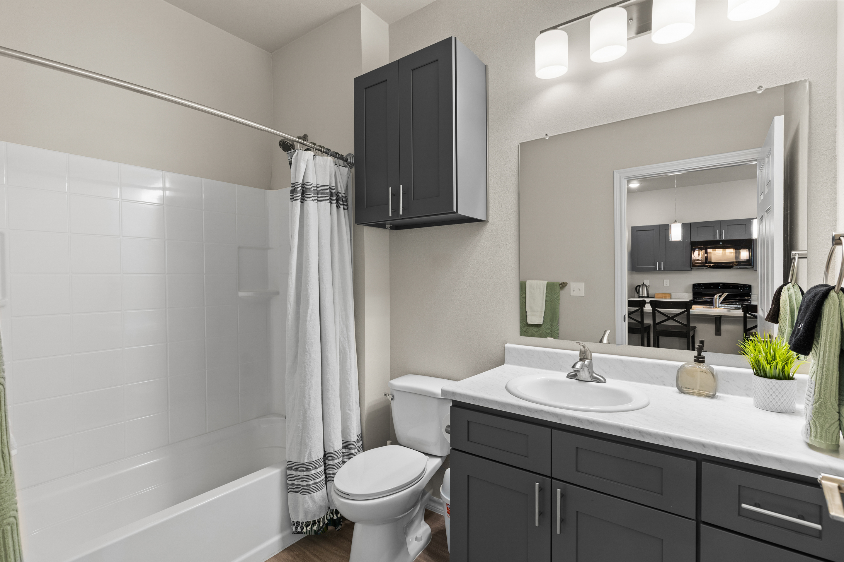 Bright modern bathroom with tub, large vanity, and stylish storage