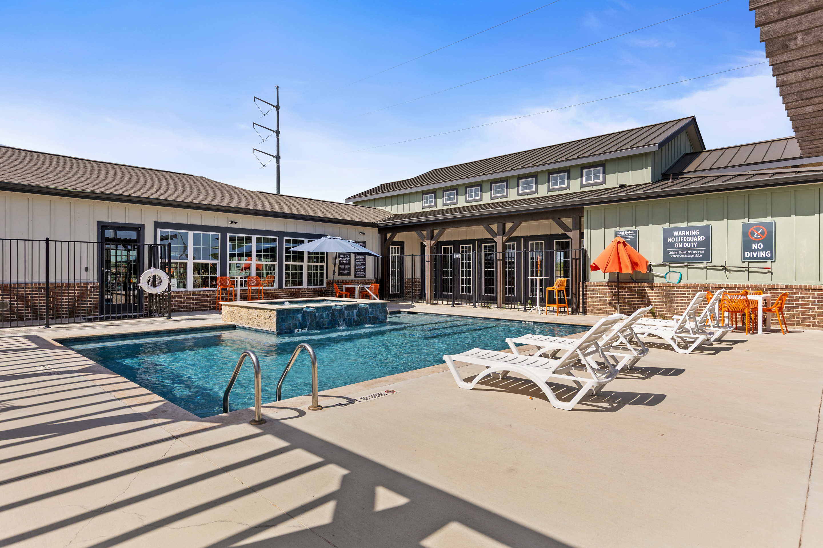 Resort-style pool with loungers, shaded seating, and sunny deck space