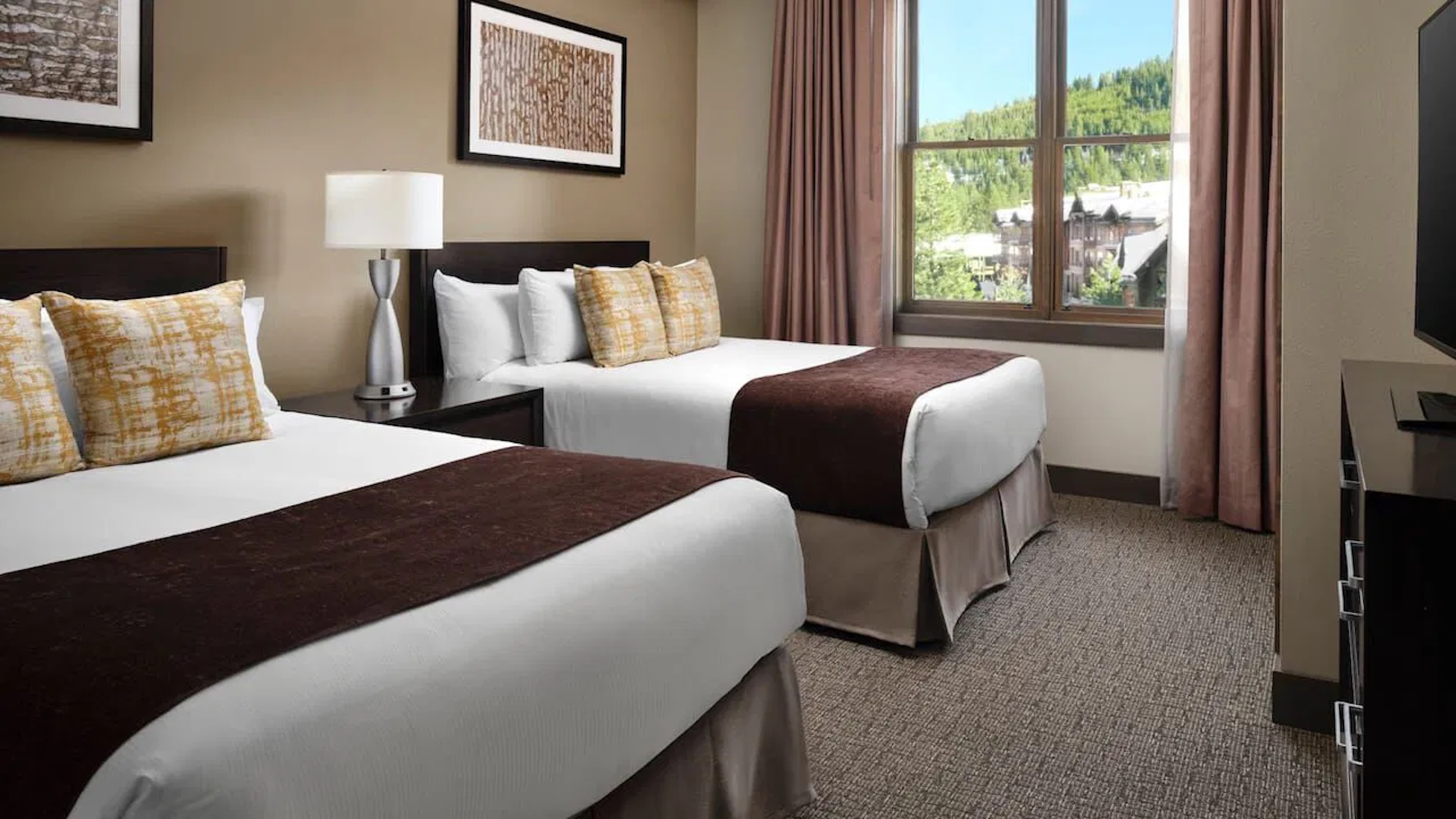 Bright double-queen room with scenic mountain views and cozy modern touches