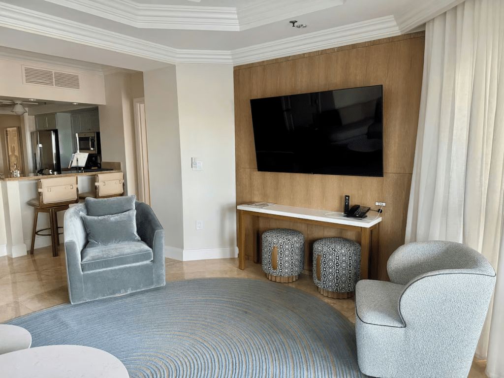 Bright, elegant lounge with large TV and cozy seating area
