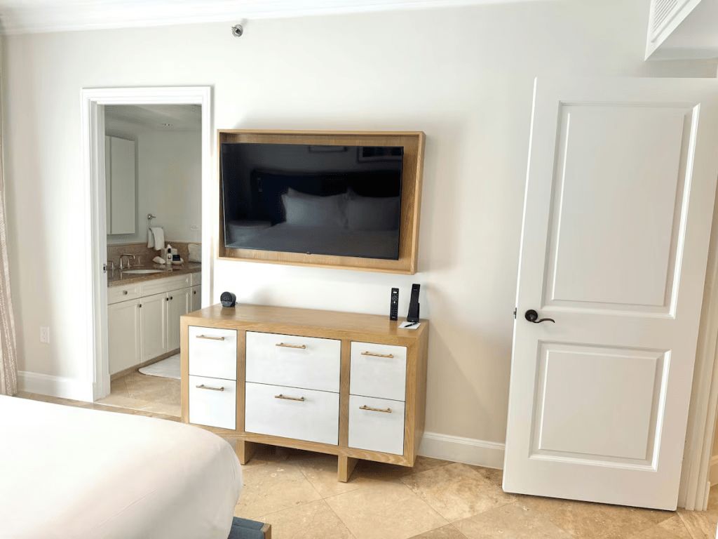 Bright bedroom with wall-mounted TV and en suite bathroom access