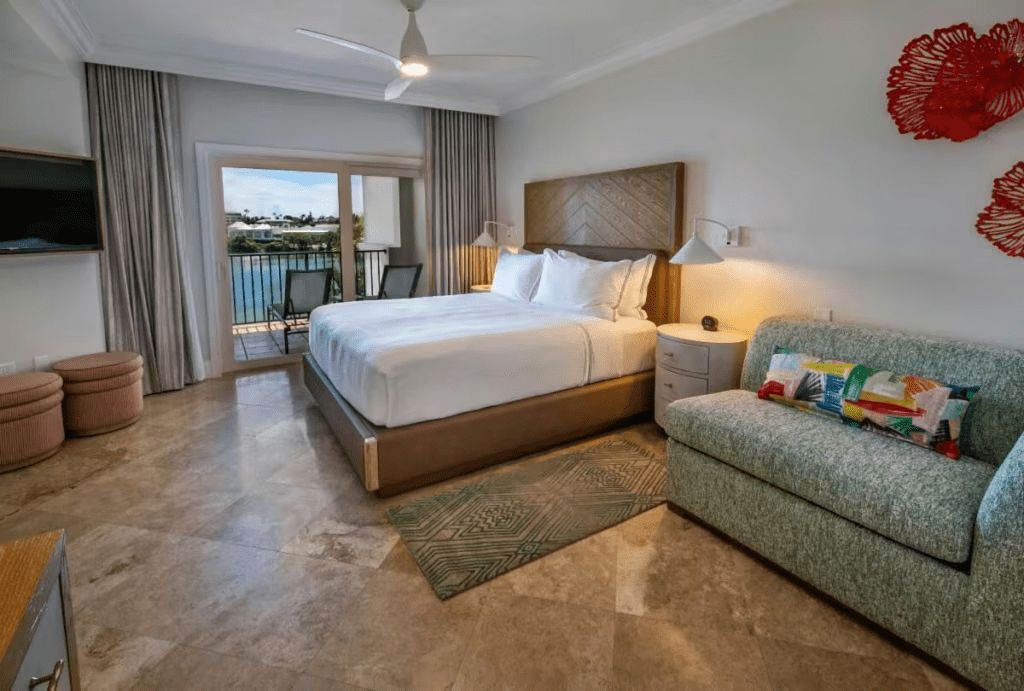 Spacious king bedroom with private balcony and serene water views