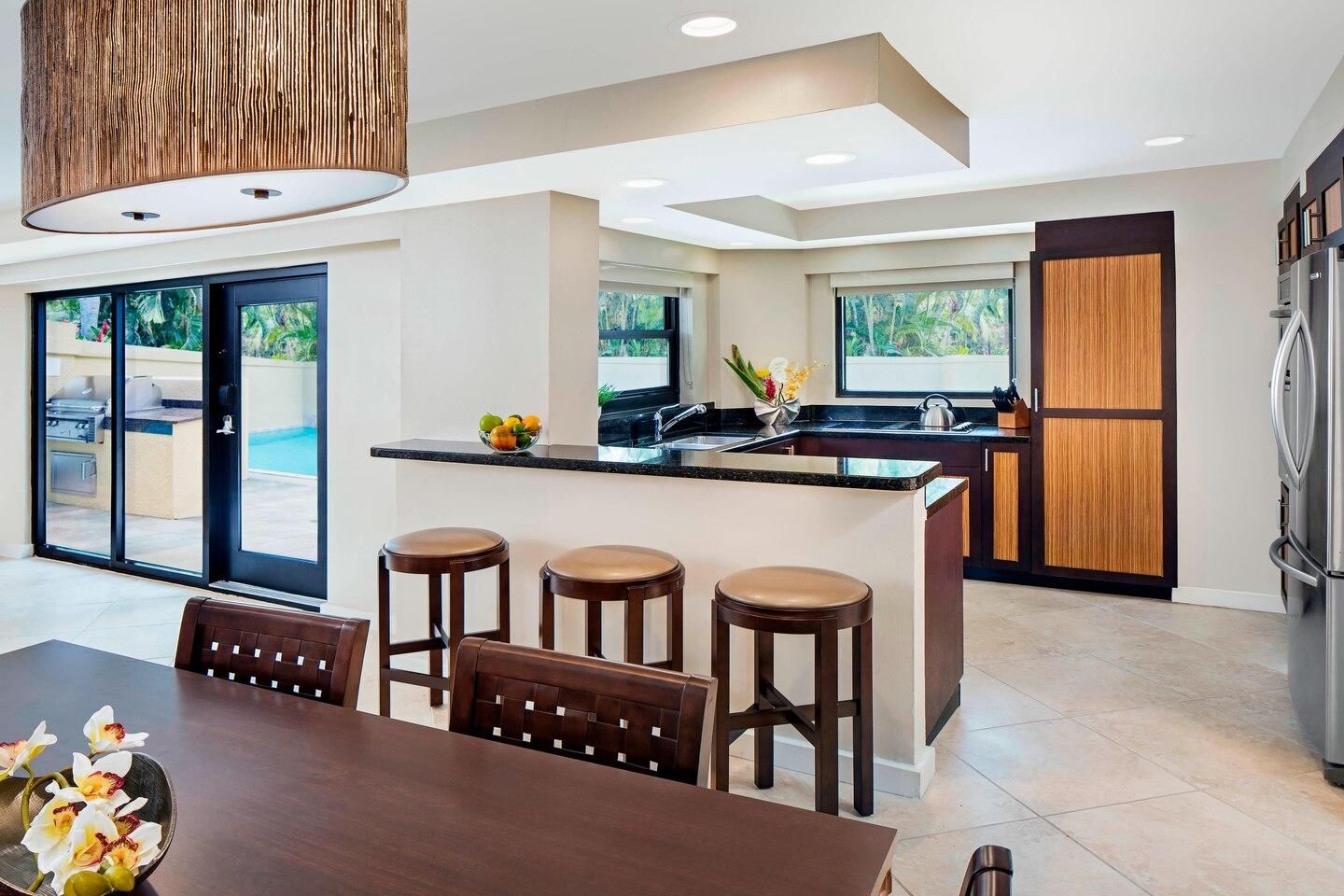 Bright open kitchen with breakfast bar and easy access to the pool patio
