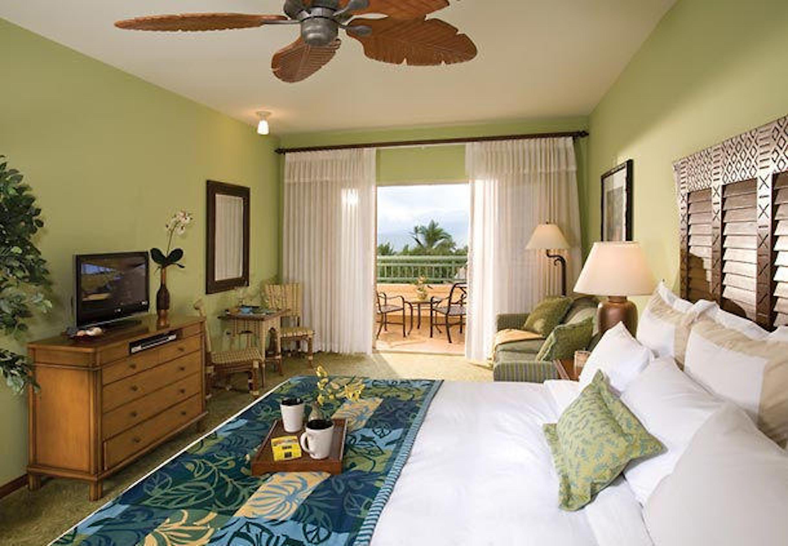 Tropical king suite with private balcony and relaxing palm views