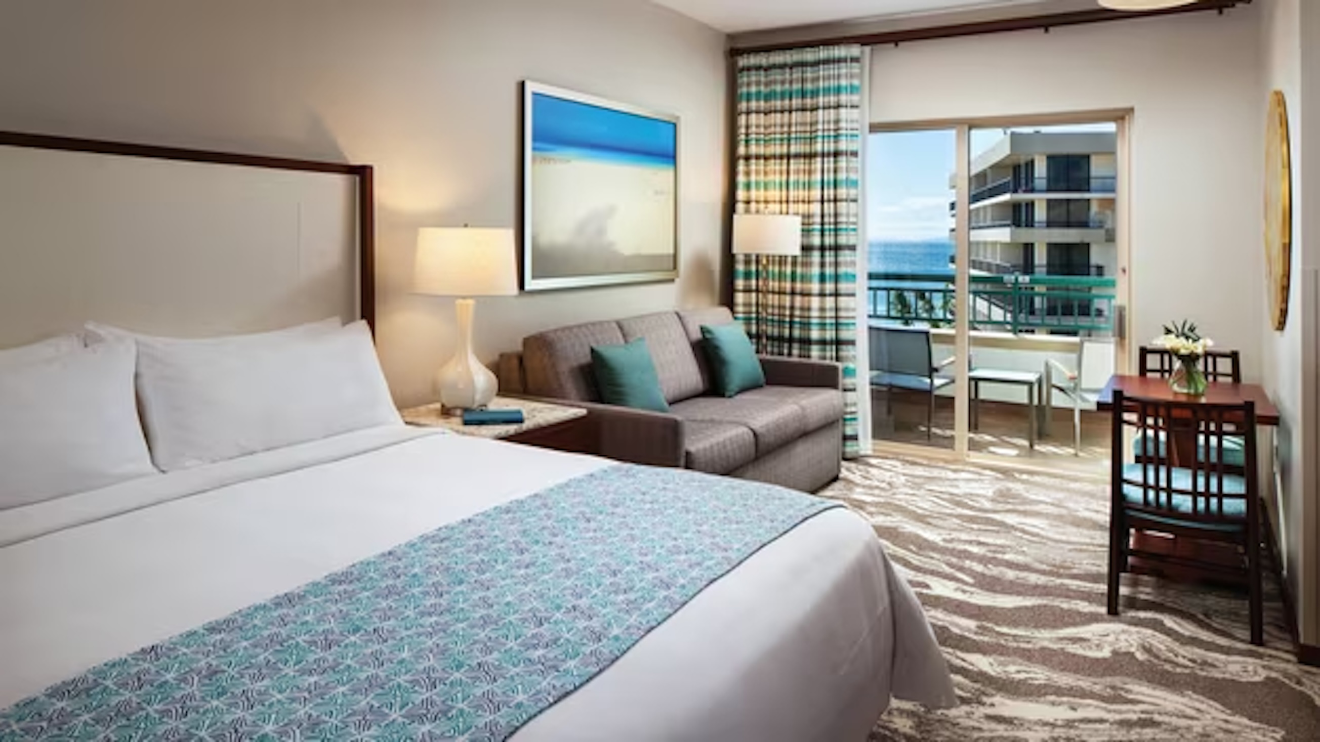 Bright coastal bedroom with private balcony and partial ocean view