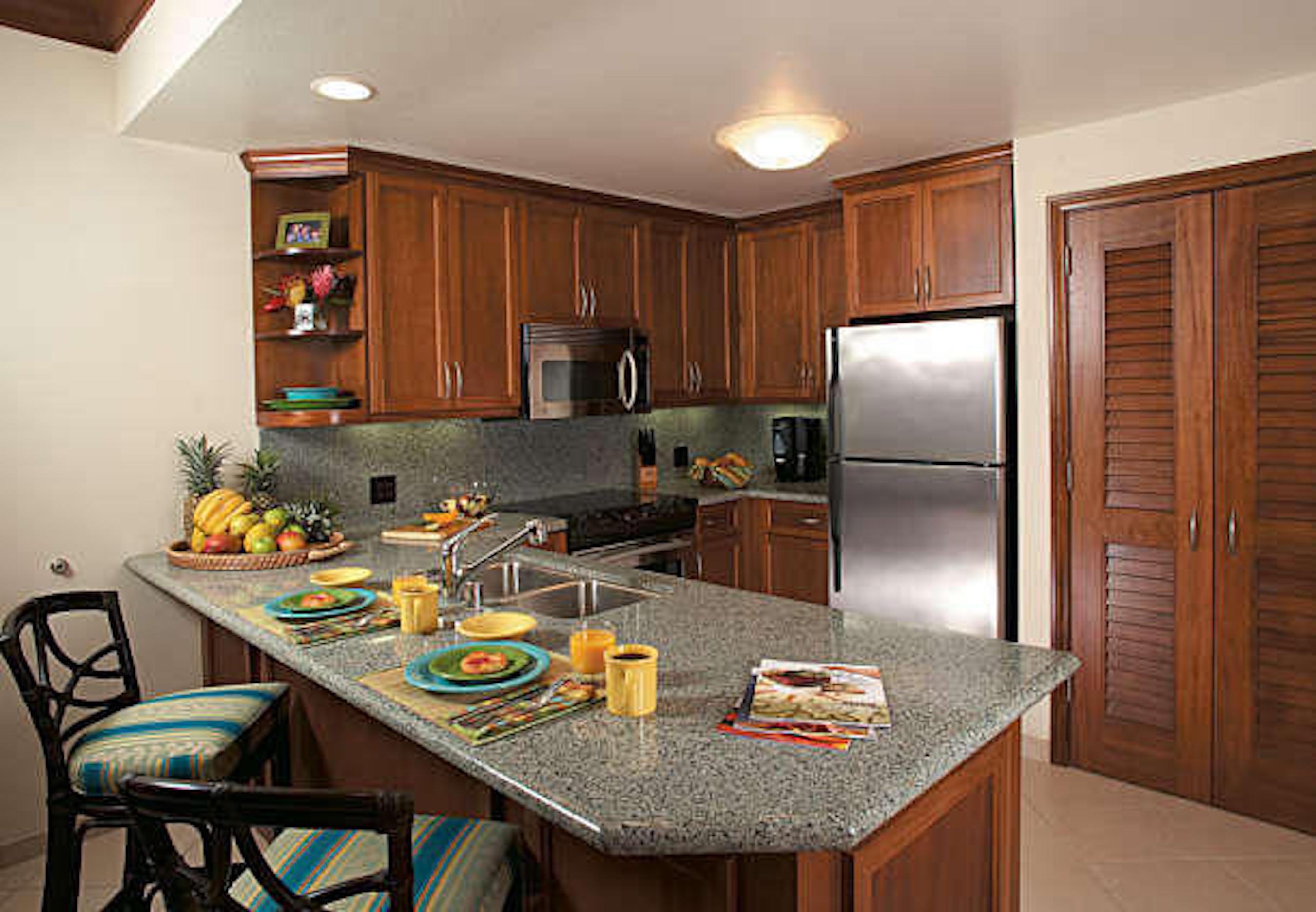 Spacious granite kitchen with island seating and stainless appliances