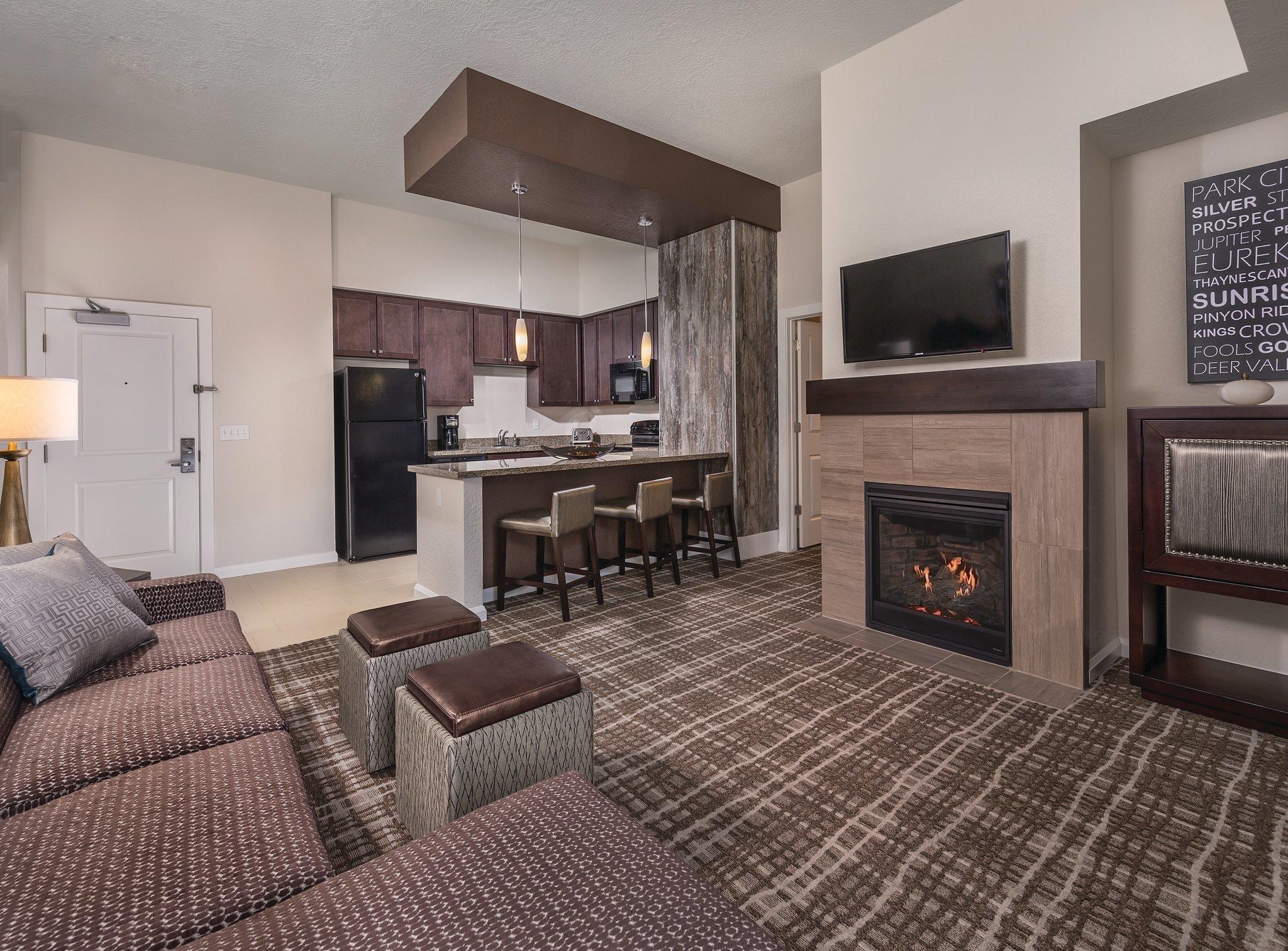 Cozy suite with fireplace, full kitchenette, bar seating, and TV