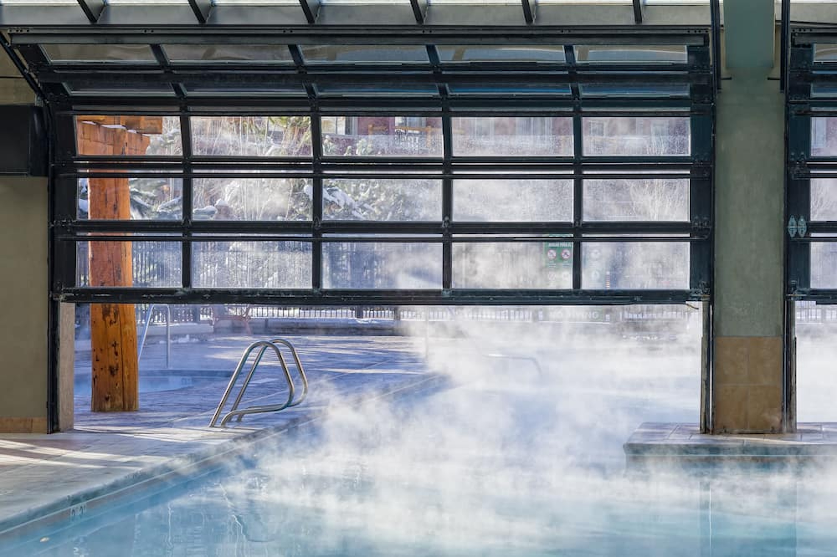 Steamy indoor-outdoor pool with mountain-lodge ambiance