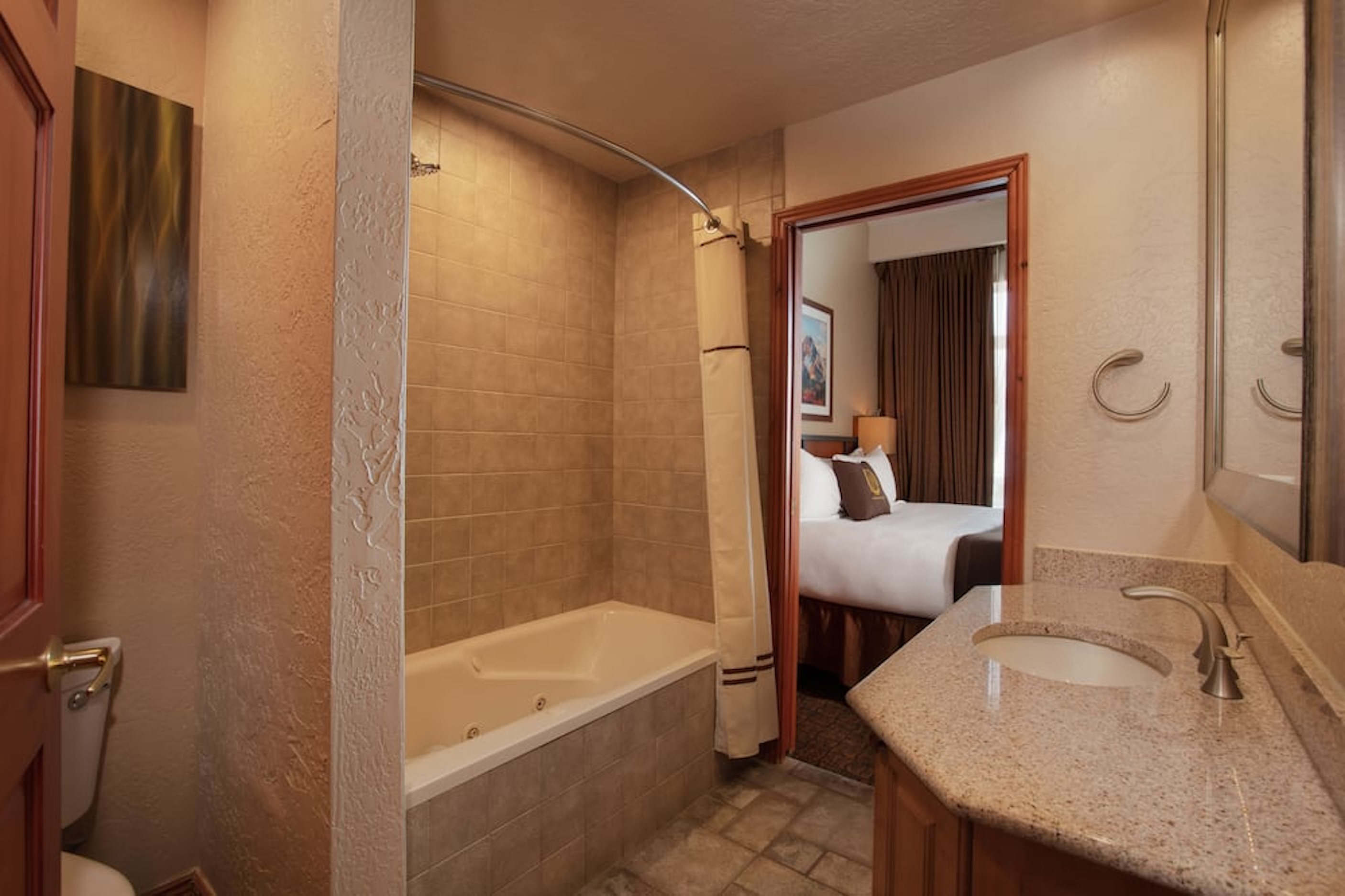 Suite-style bathroom with granite vanity and relaxing soaking tub