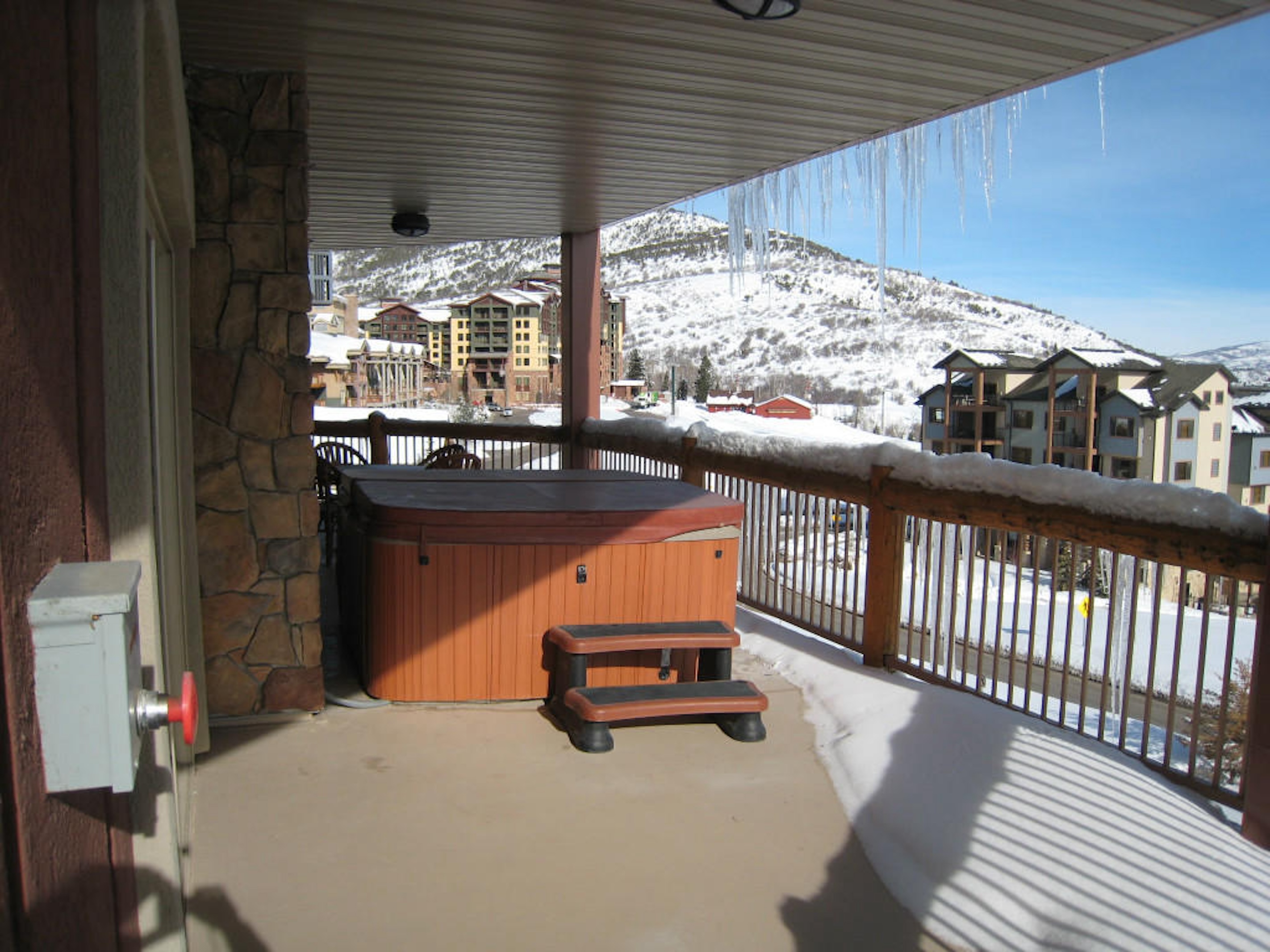 Private hot tub on a covered balcony with stunning snowy mountain views