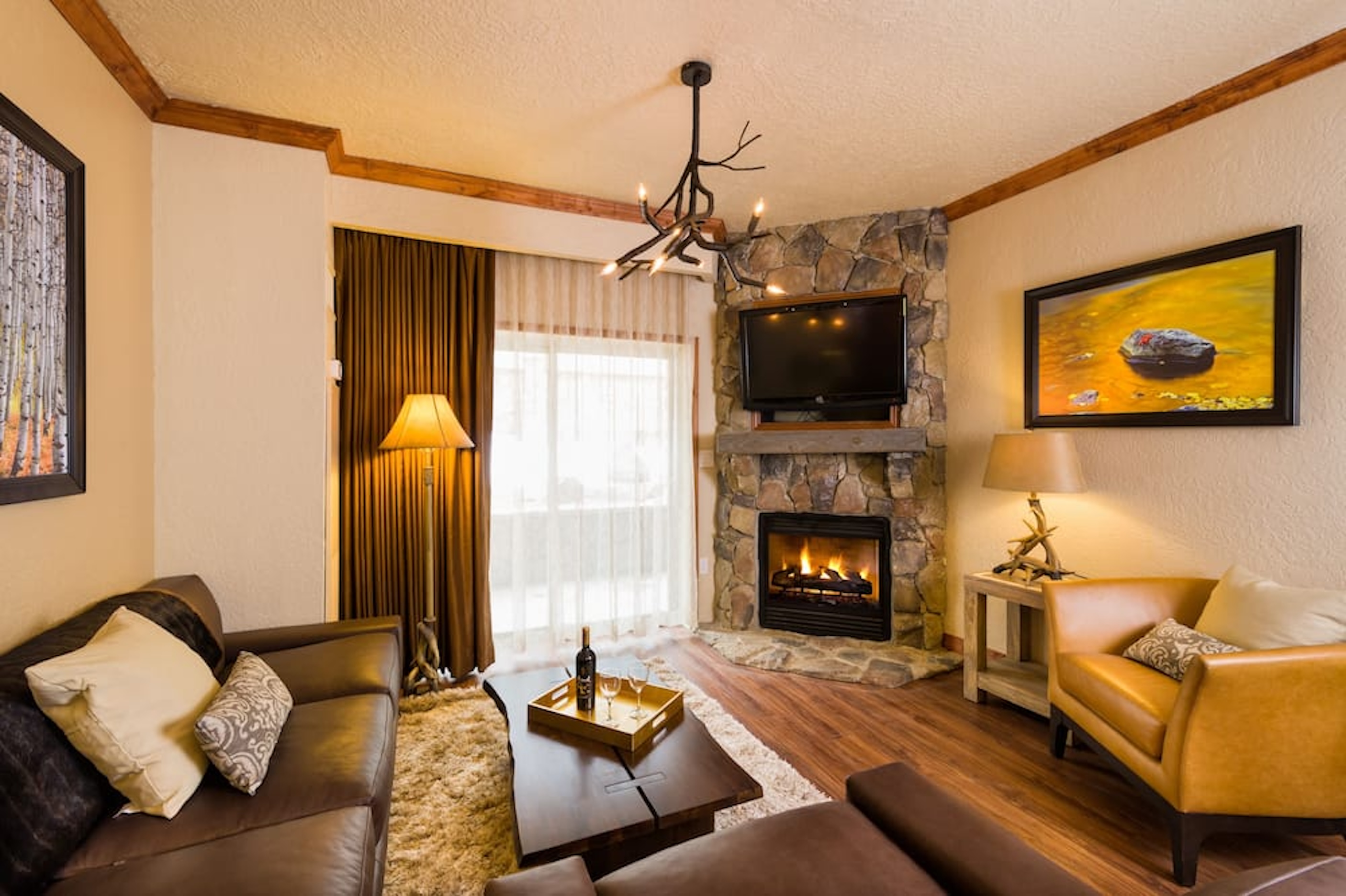 Cozy lodge-style living room with stone fireplace and warm rustic charm