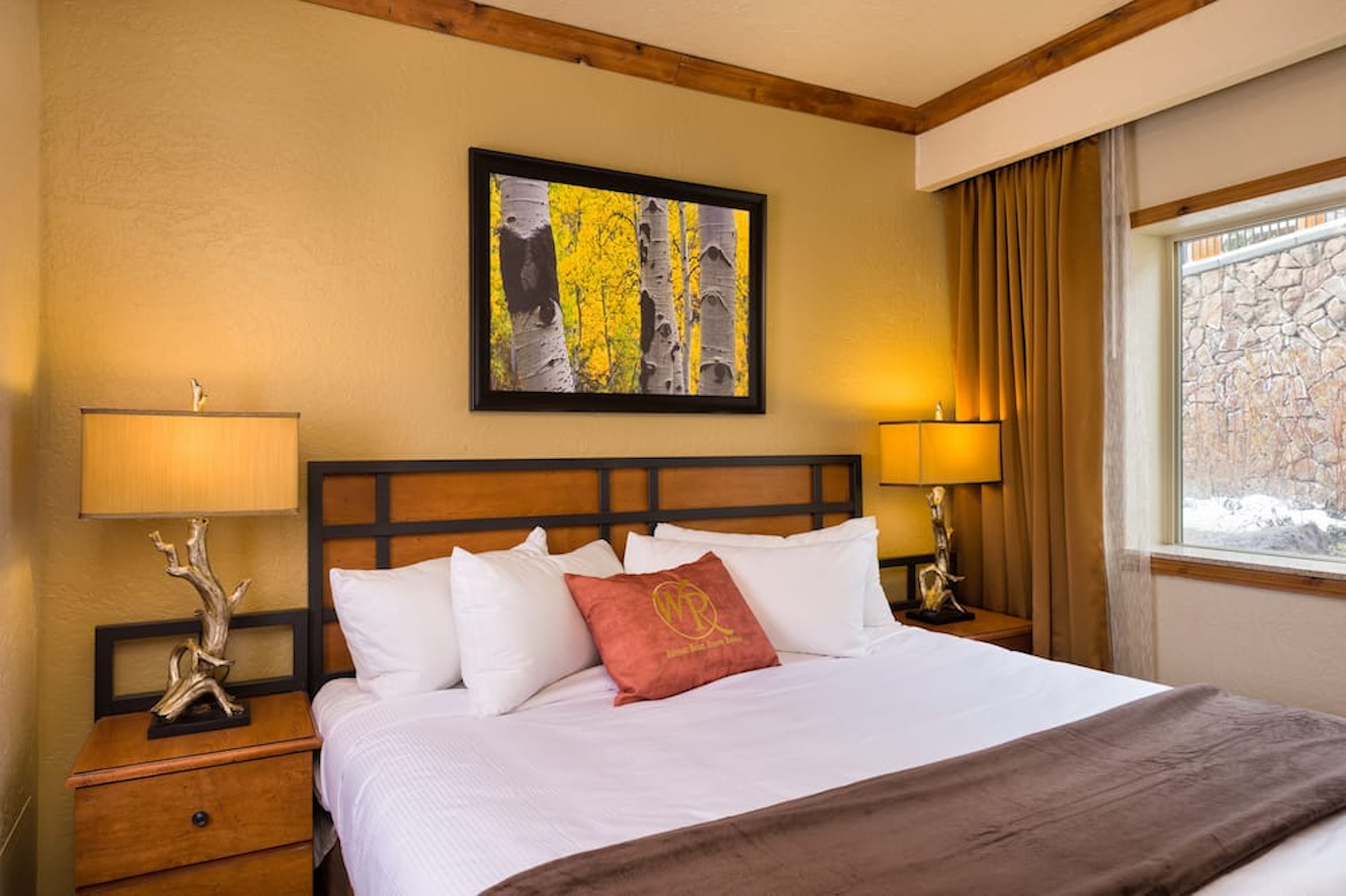Cozy king bedroom with warm lodge style and bright natural light