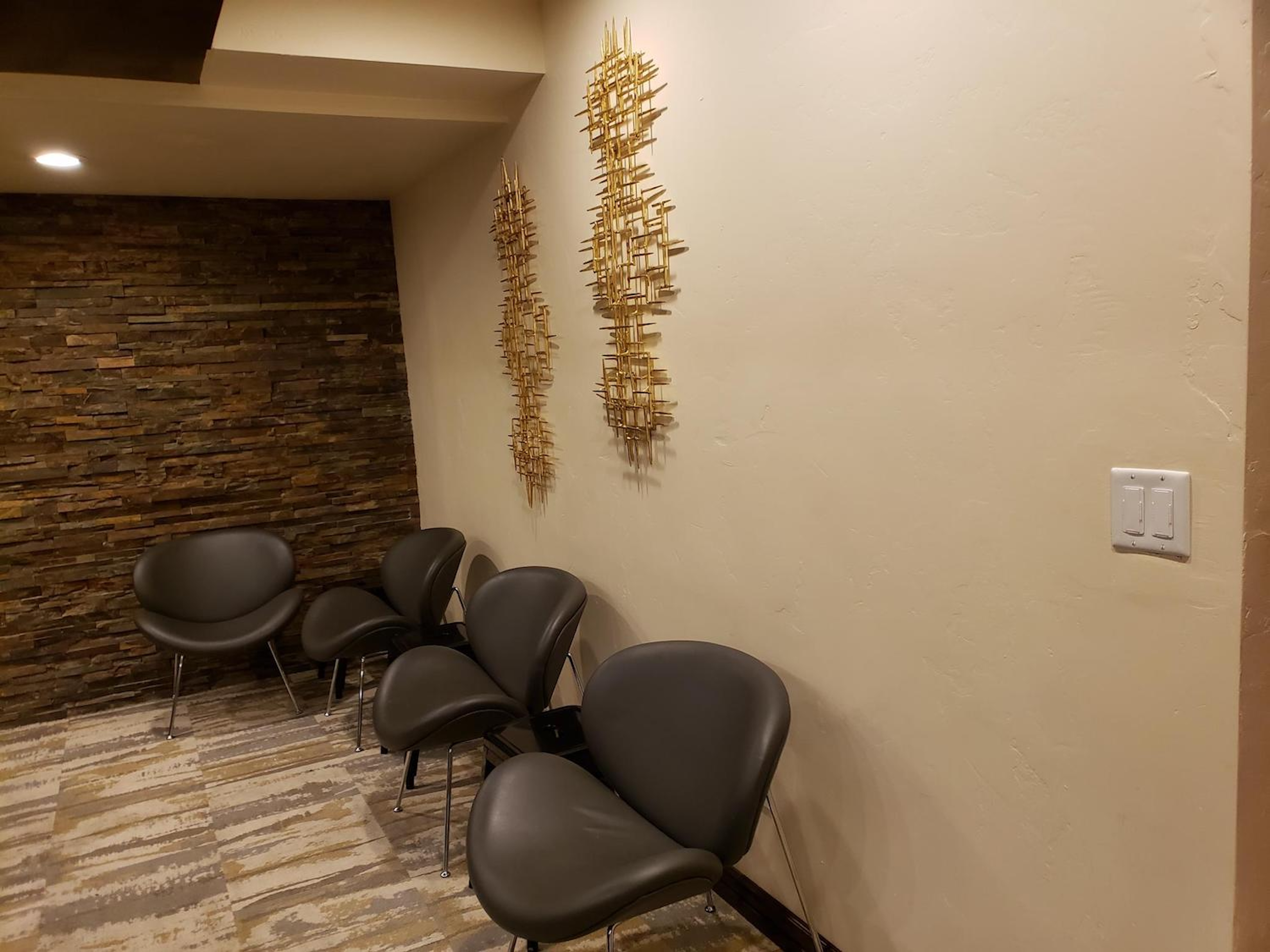 Stylish lounge nook with modern seating and elegant stone accent wall