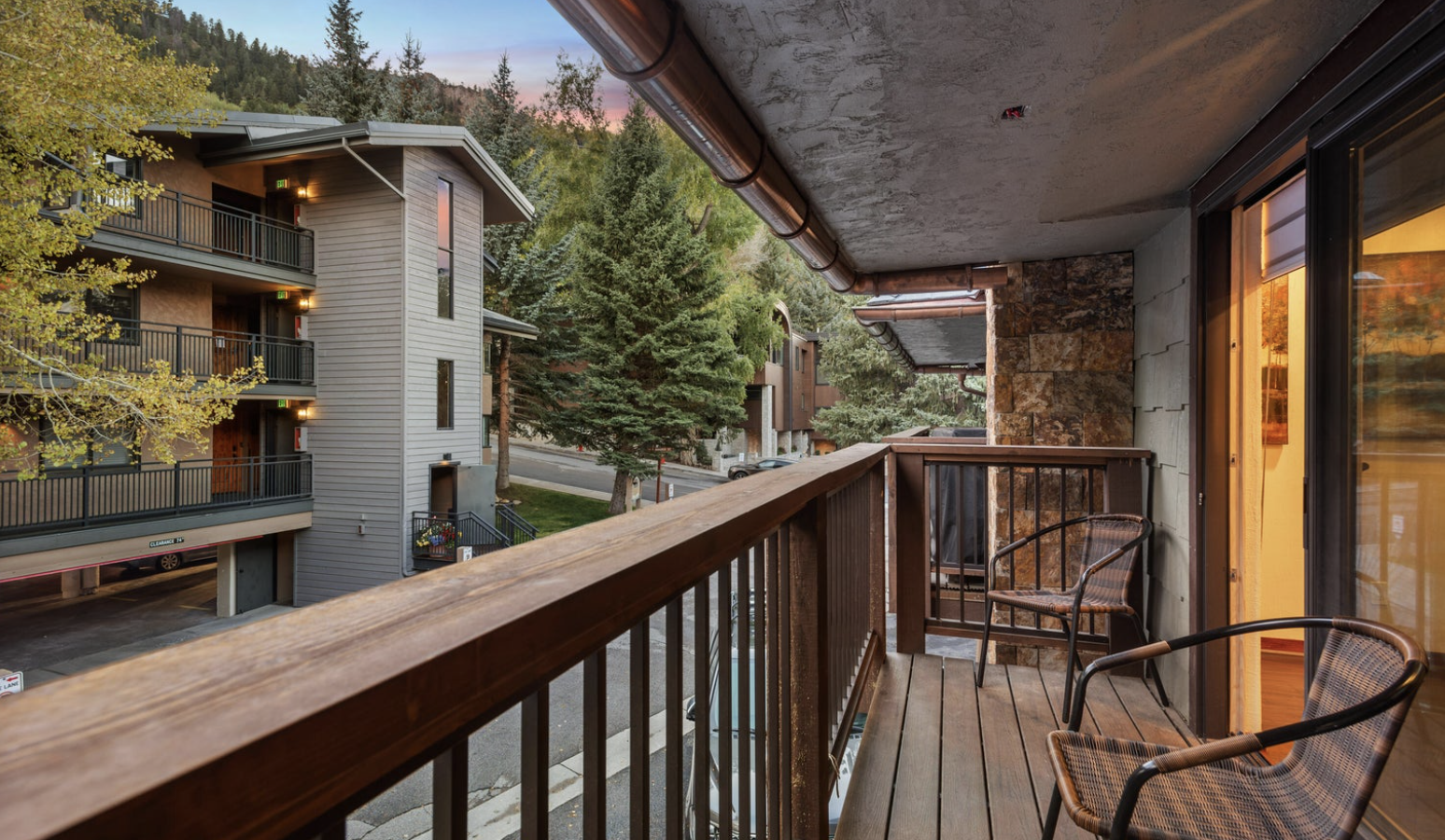 Private covered balcony with seating and peaceful wooded views