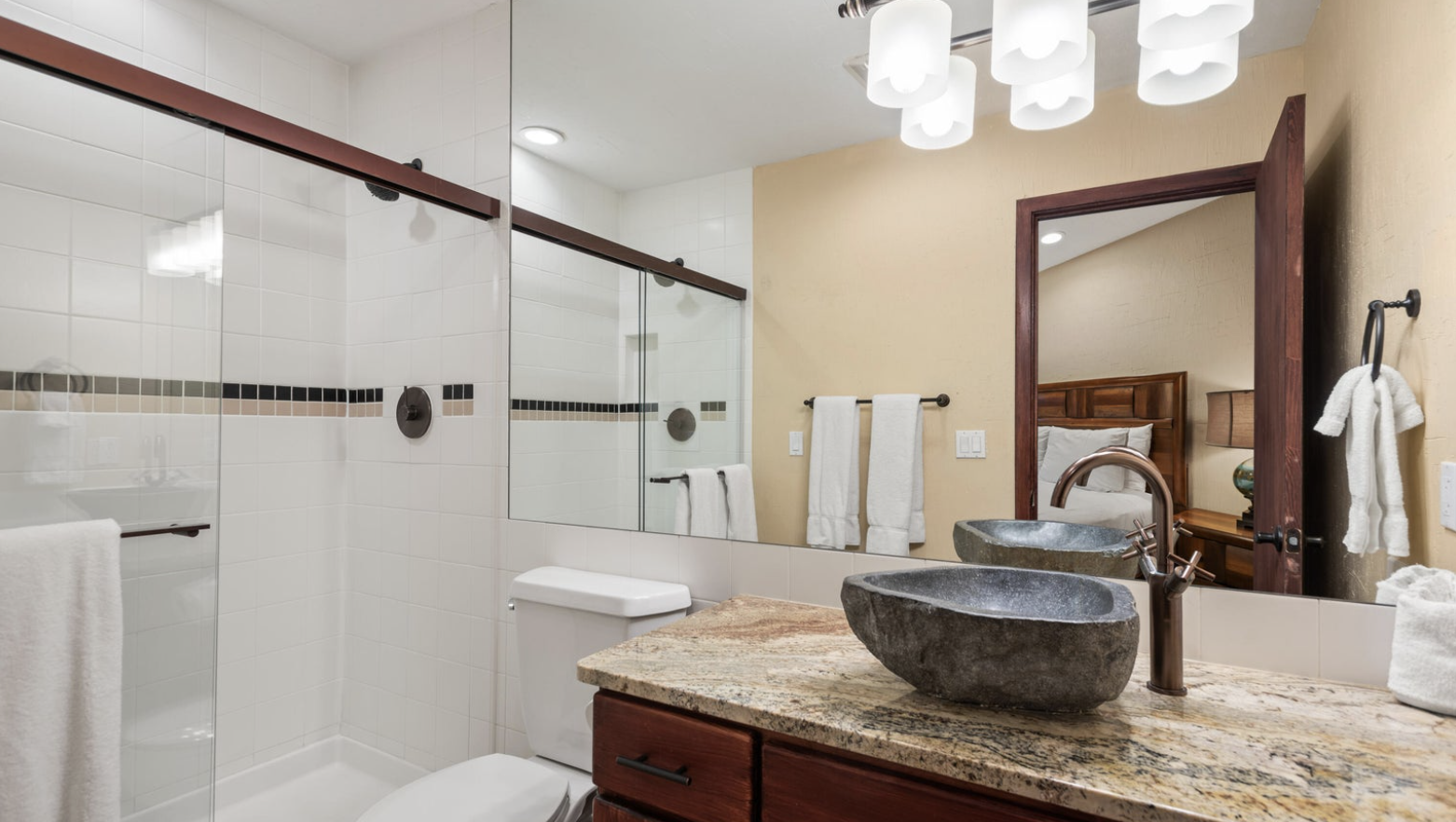 Upscale bathroom with double stone sinks and glass walk-in shower