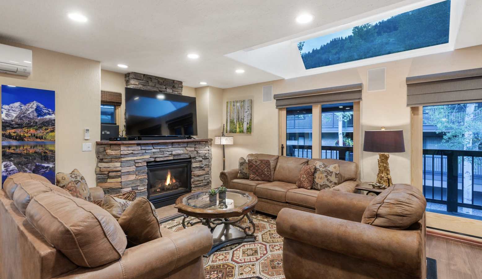 Cozy mountain-style living room with fireplace, TV, and scenic natural light