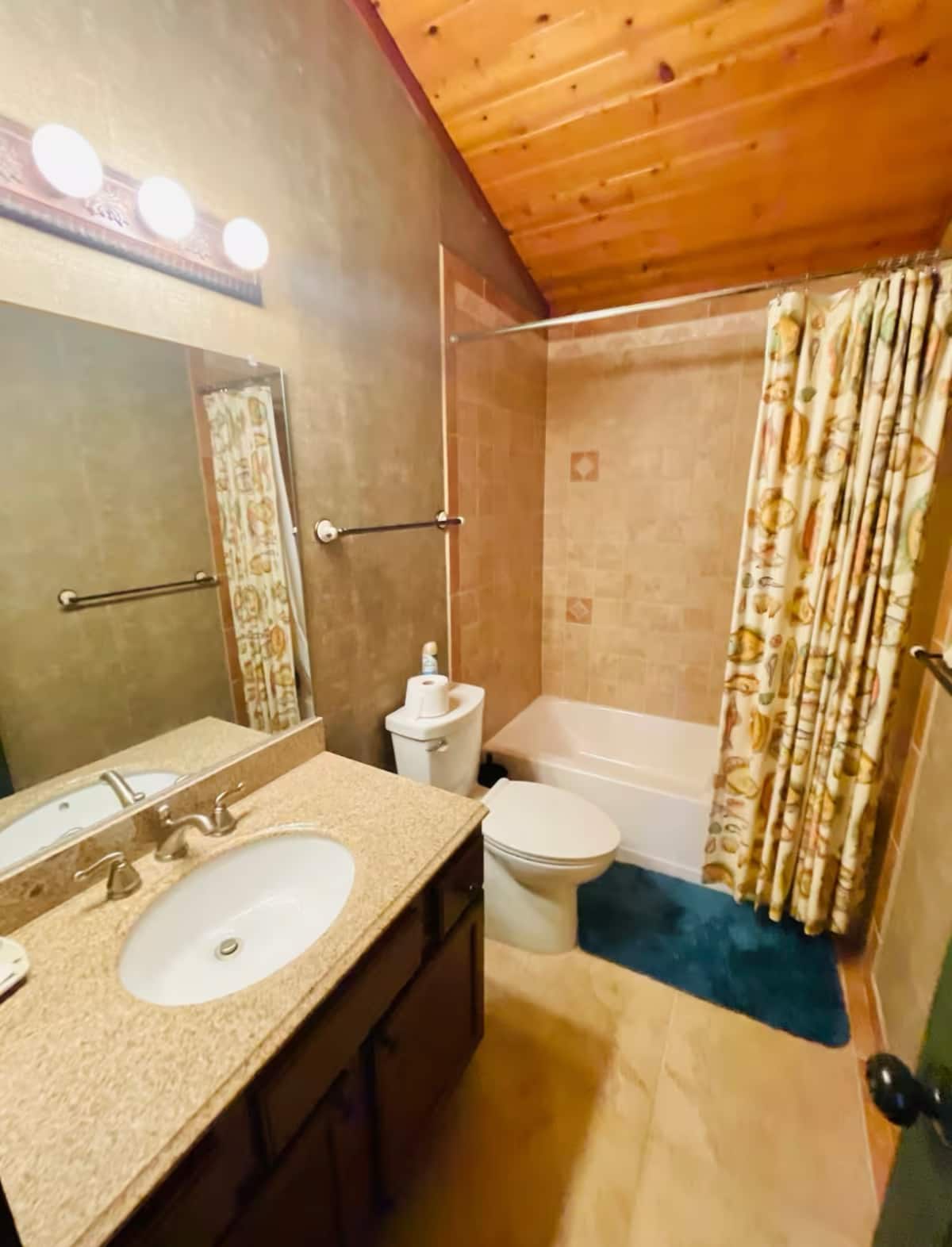 Cozy rustic bathroom with bright vanity and tub-shower combo