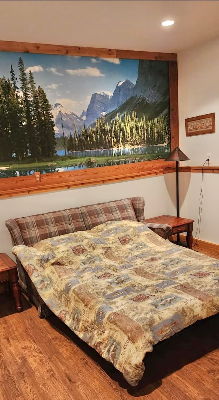 Cozy rustic sleeping nook with mountain mural and warm cabin charm